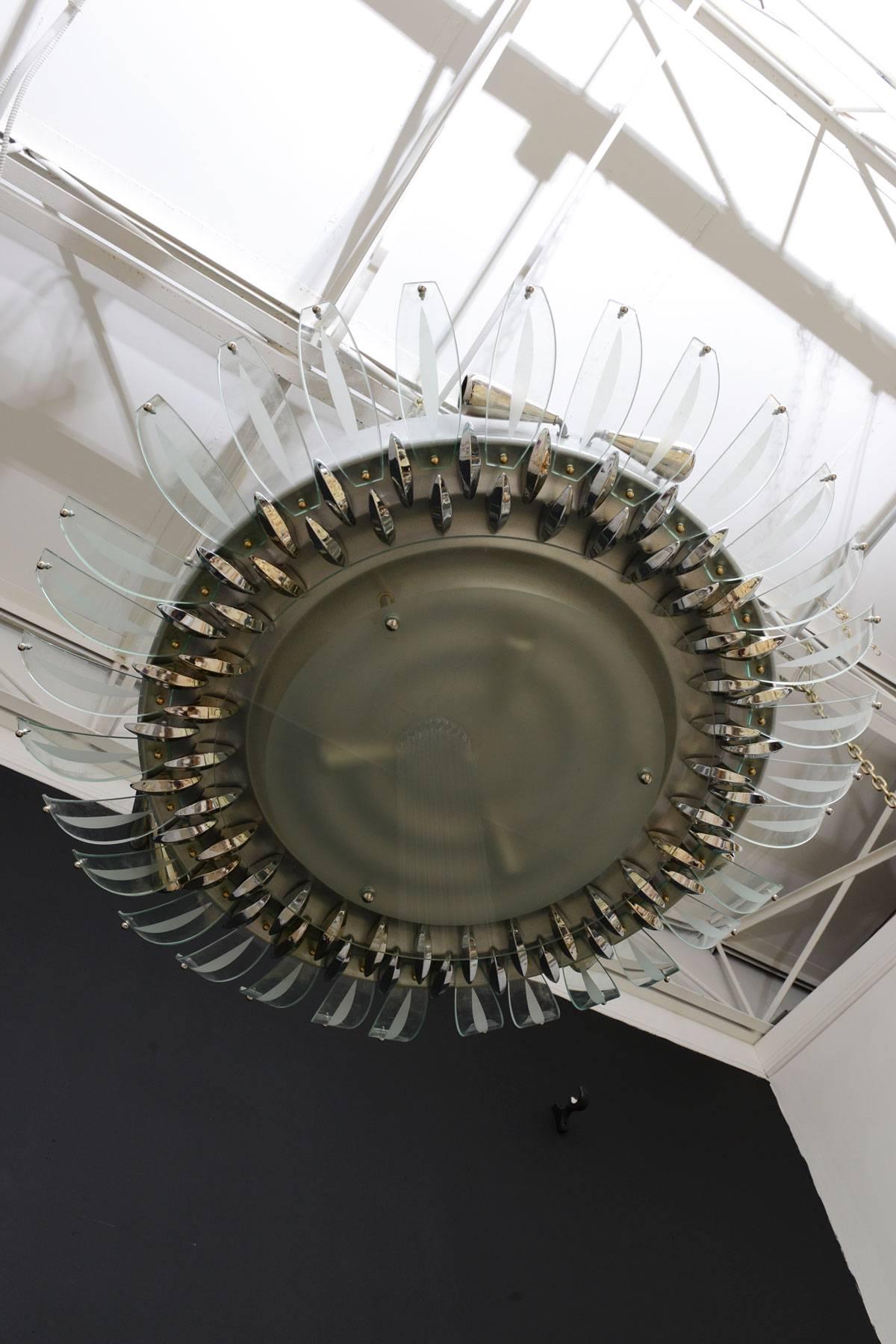 Large Italian glass disk flush mount chandelier with chrome and glass leaf-like projections around the diameter.