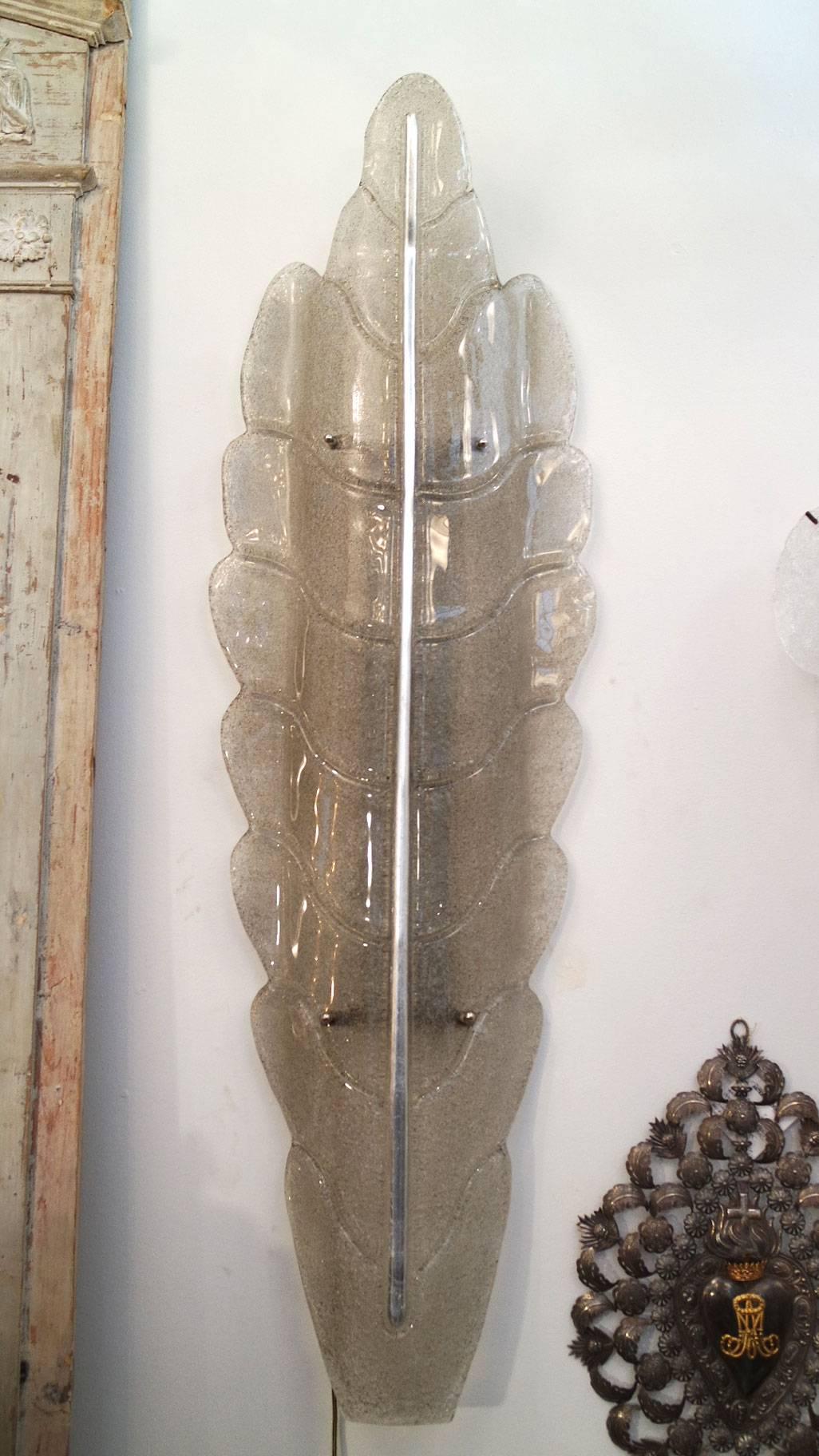Dramatic and large pair of Murano glass leaf sconces with lightly smoked glass: smooth on outside, textured inside. The armature is aged silver tone which runs vertically up the centre of leaf.