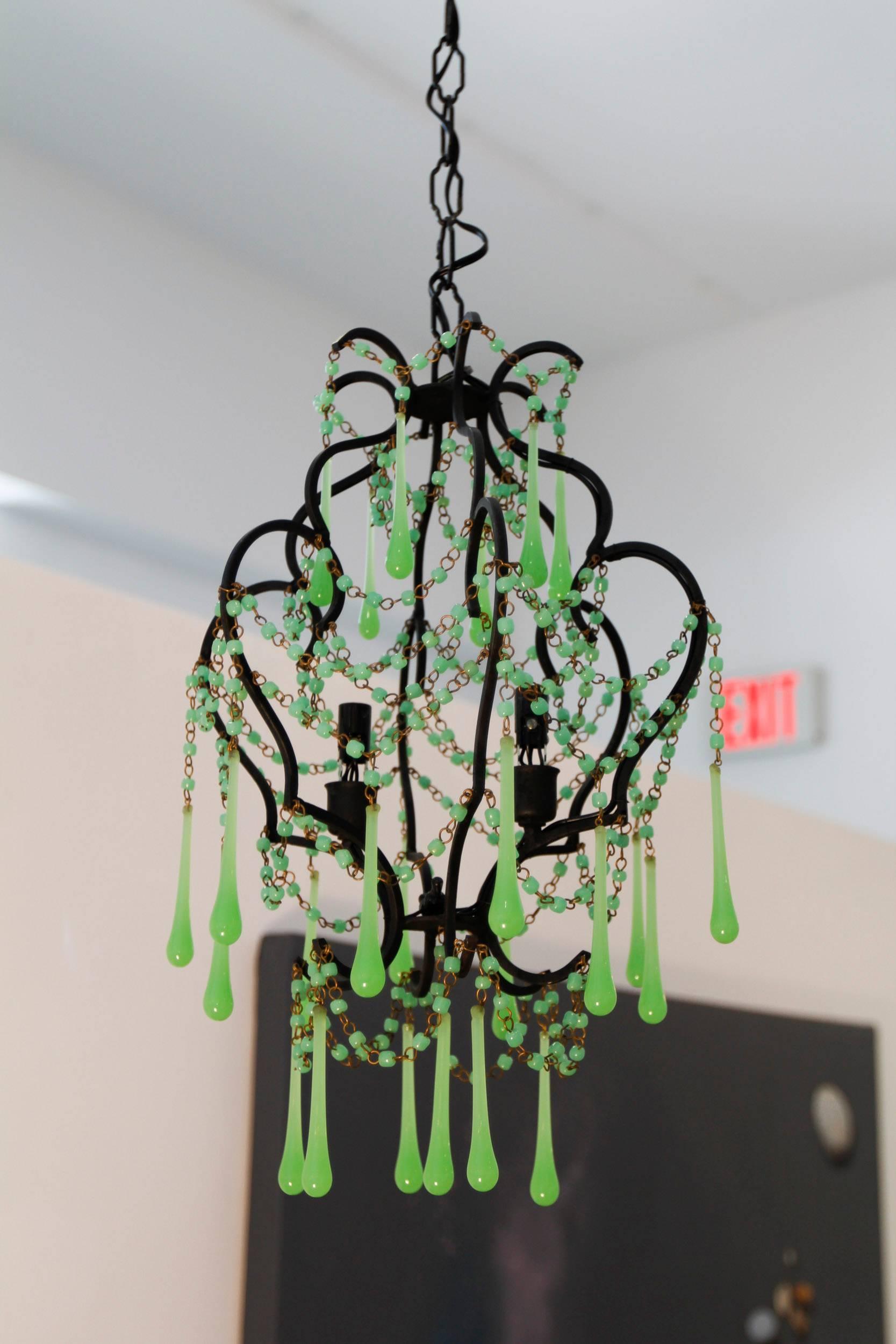 Pair of opaline chandeliers with jade green elongated drops. The chandeliers are sold as the pair. The frames are painted flat black.
Measure: 21