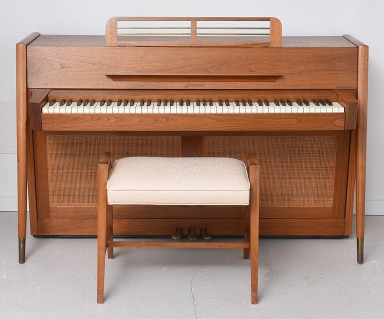 Rare teak Mid-Century Modern spinet piano by Baldwin. This is a limited production piano made only between 1961-1964. It has the original bench as well. It is attractive from all angles and can be floated in a room. It plays nicely but of course can