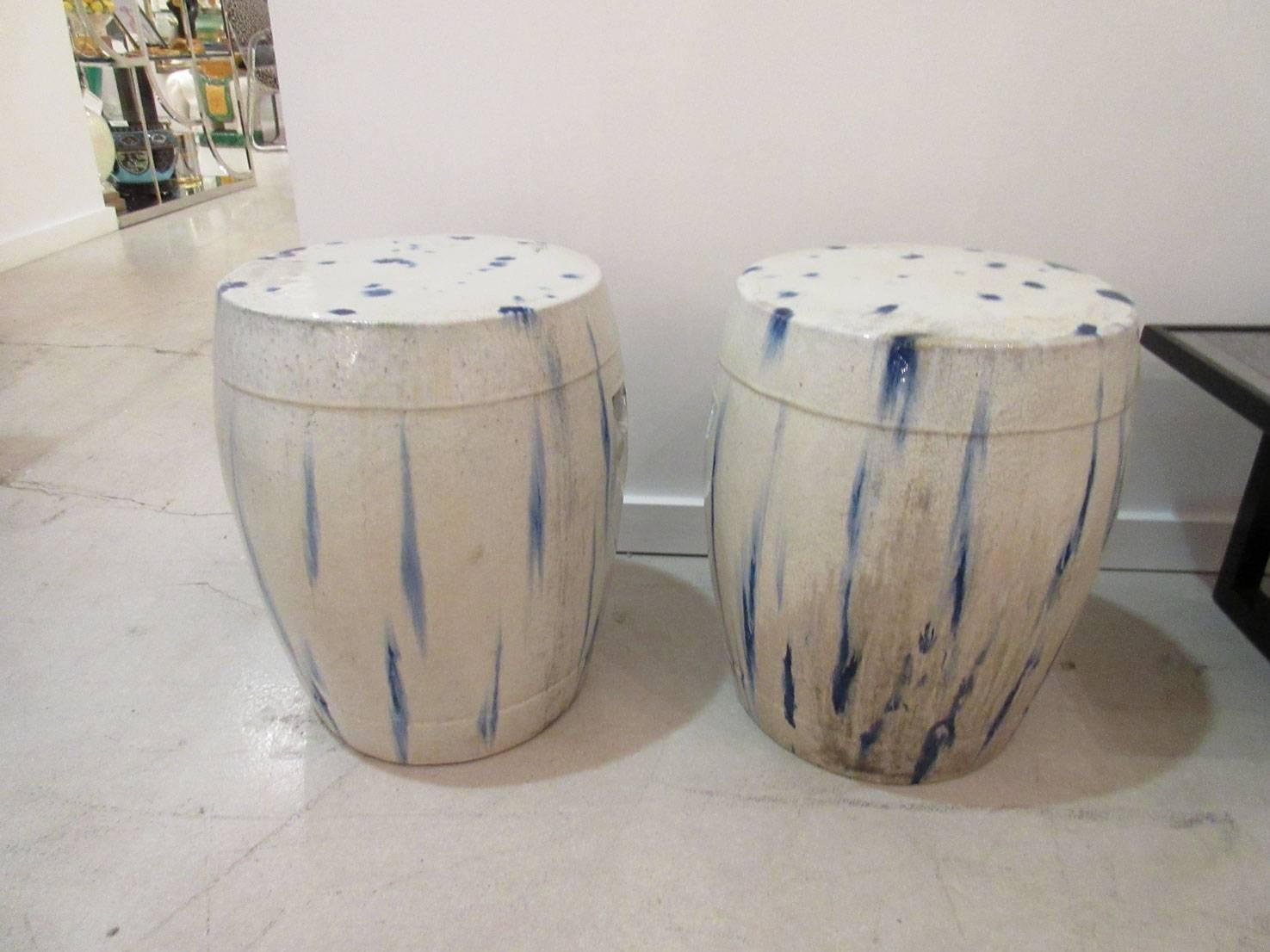 Pair of white Chinese ceramic garden seats with blue and green stain painting or tie-dye effect and fine surface craquelure.