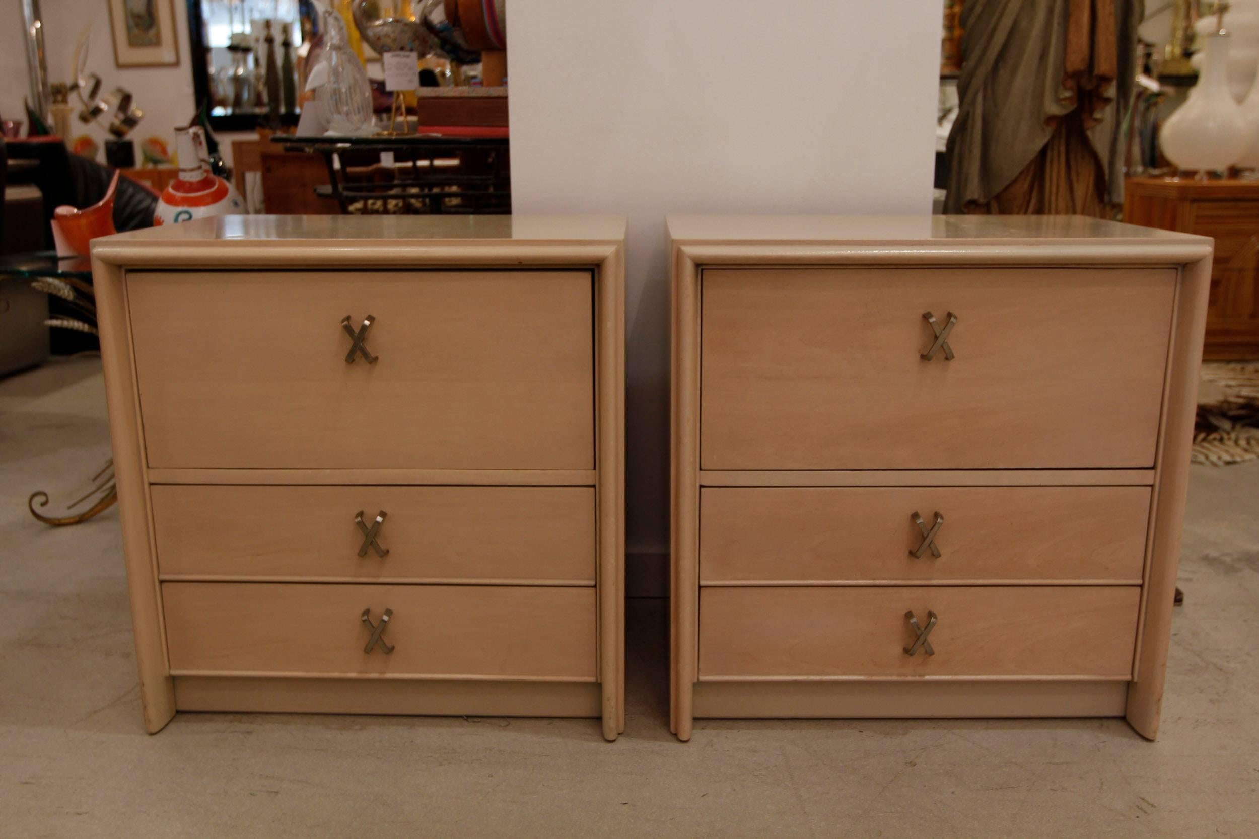 Pair of Paul Frankl bedside tables with X-handles. This pair coordinates with the other pieces we are offering including the long chest of drawers, the tall chest and the mirror. All items are listed and sold individually.