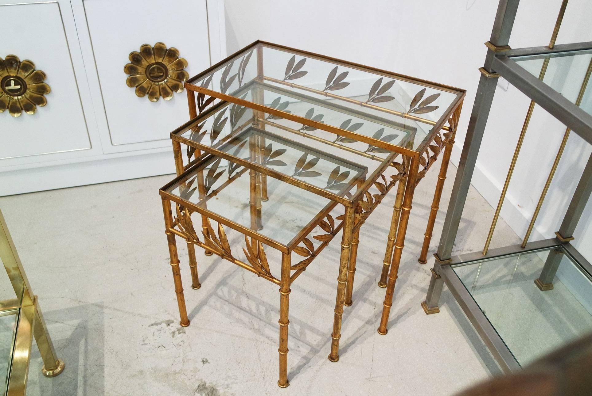 Set of three gilt bamboo Italian nesting tables with glass tops. The trio nestle into each other.
Two sets available, sold separately.