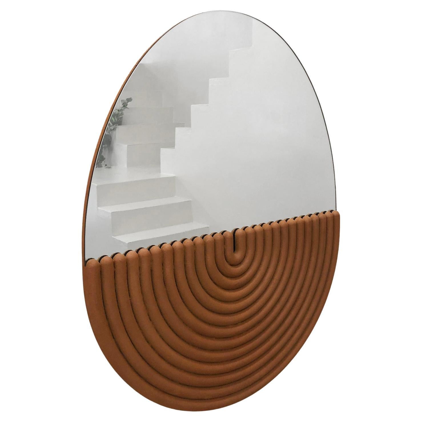 This modern hand-cast reinforced gypsum mirror is an original Ian C.R. Martin Studio piece. It features a striking, concentric design using a backcasting method that integrates the mirror seamlessly into its plaster frame.  The plaster is reinforced