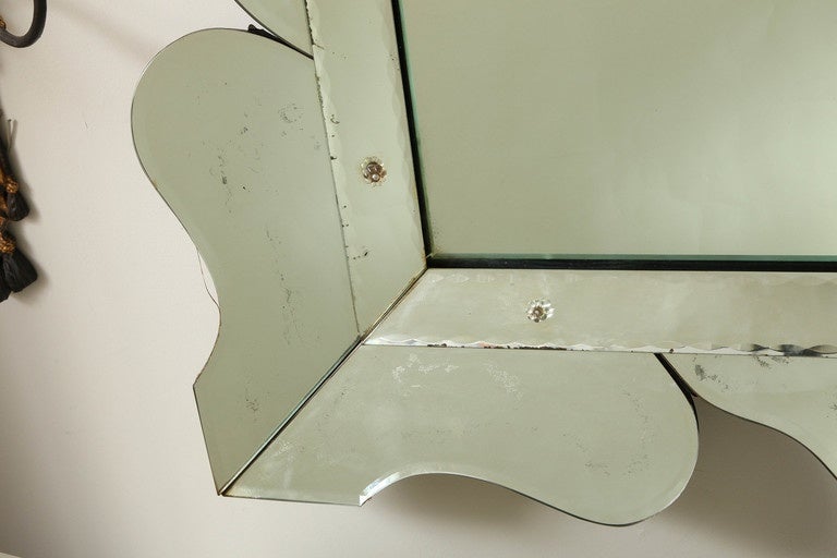 A large scale rectangular American mirror. The frame surrounded by shaped elements framing mercury silvered center glass.