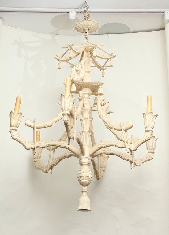 A six-light Italian carved wood Chinese inspired chandelier. The painted ivory chandelier with faux bamboo frame and carved monkey figure seated on upper section, having carved wood bell and pagoda shaped top.