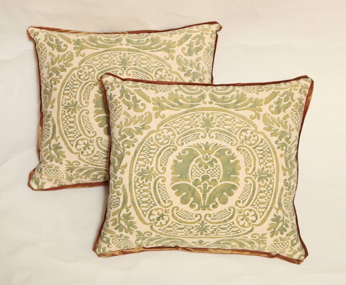 A pair of Fortuny fabric cushions in the Orsini pattern, blood orange silk blend backing and bias silk trim, the pattern a 17th century Italian design named for one of the most princely families in medieval Italy and renaissance Rome, the Orsini.
