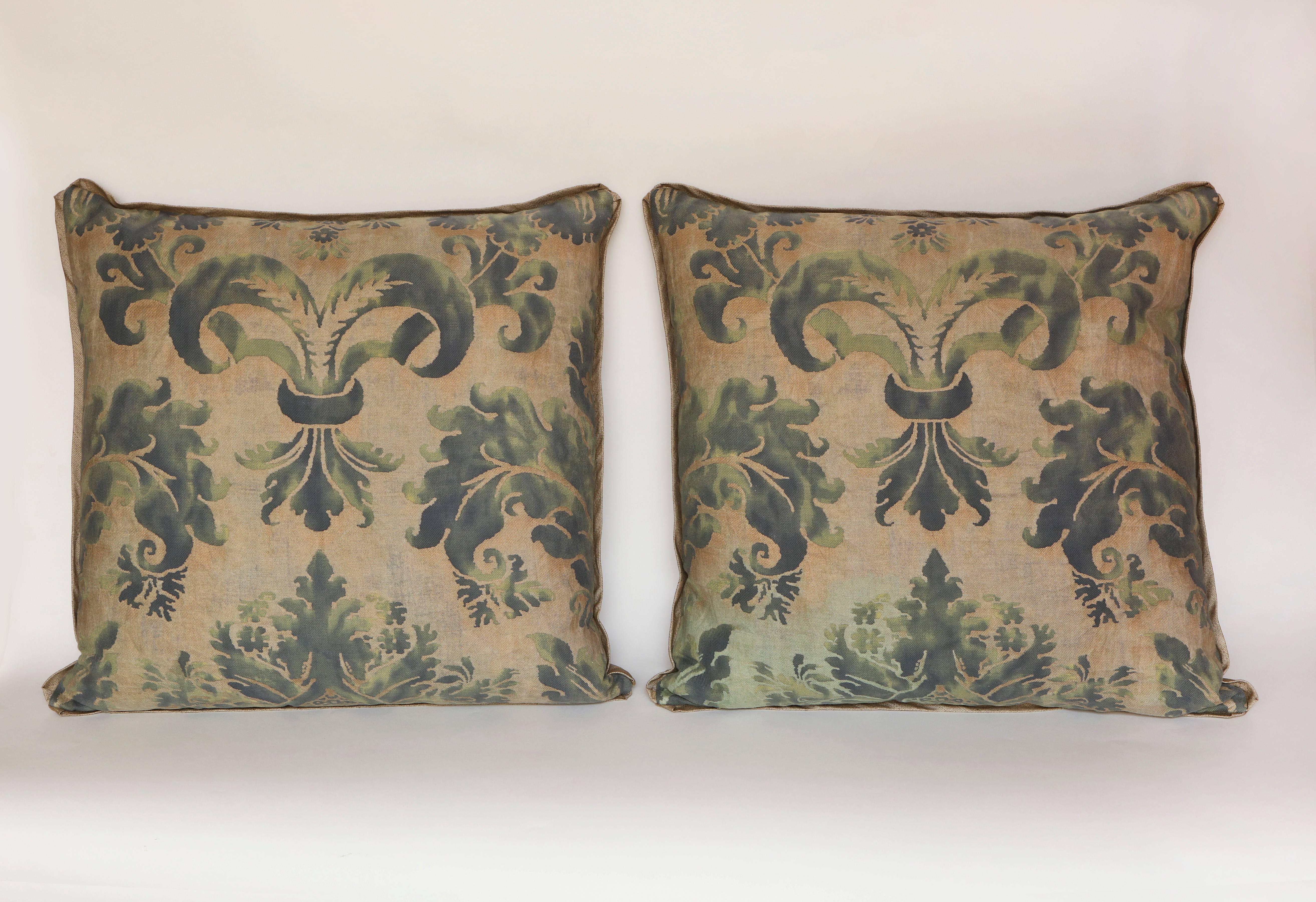 A pair of square Vintage Fortuny fabric cushions in the Glicine pattern, a 17th century Italian design. Green colorway with silk edging.