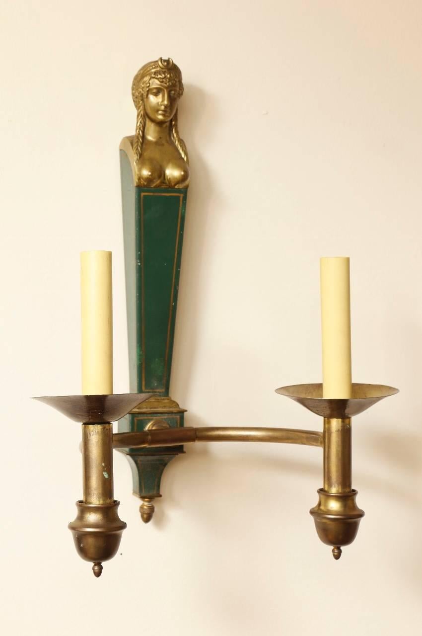 French Empire style two-light bronze and tole wall sconces with female busts above square and tapered backs.