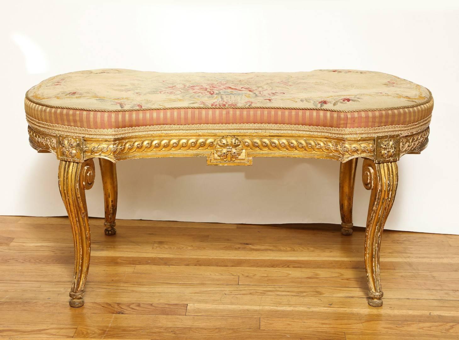 A French Louis VX style bench, the carved and giltwood frame having cabriole legs and shaped apron. The seat upholstered with fine late 19th century Aubusson tapestry, circa 1920.