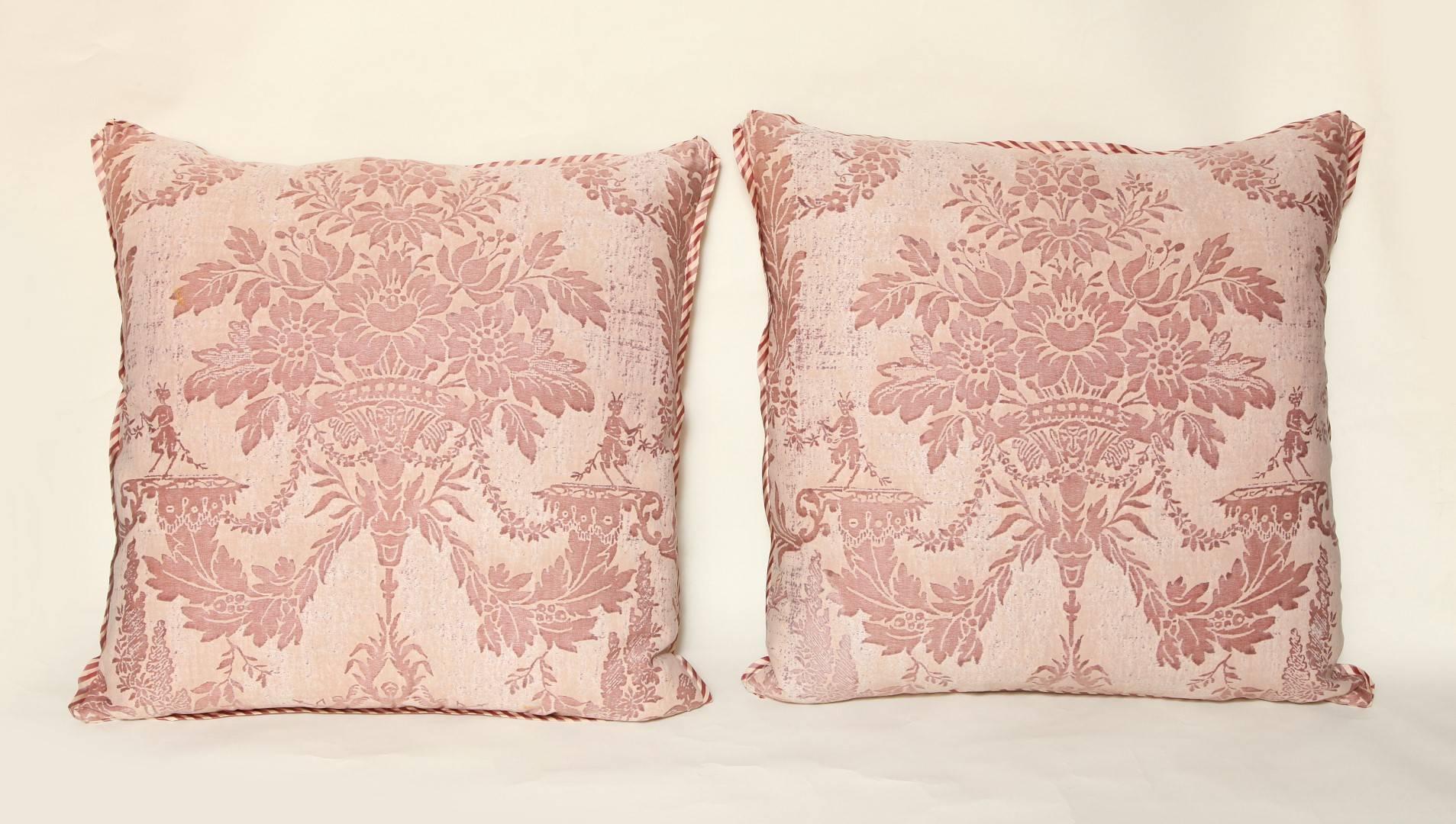 A pair of Fortuny cushions in the Boucher pattern, beige and rose color way with bias silk striped edging and raw silk back, the pattern named for the most celebrated painter and decorative artist of the 18th century, Francois Boucher (1703-1770.)