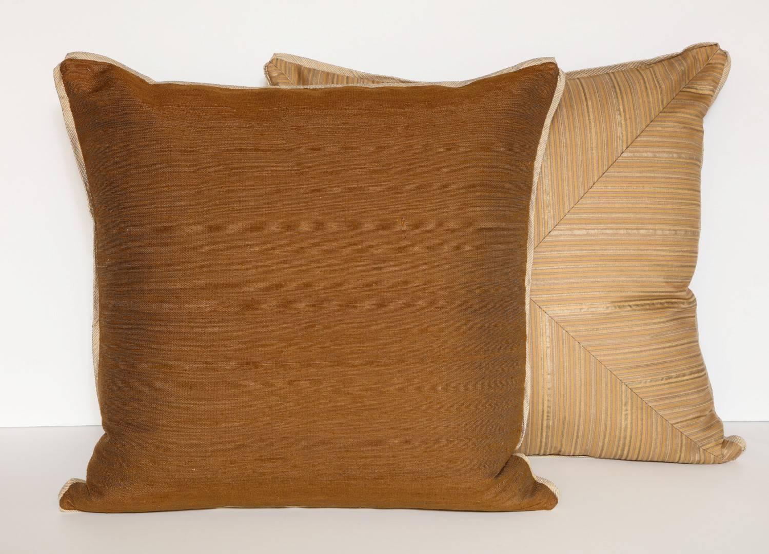 A pair of mitered Fortuny fabric cushions in the Malmaison pattern, silk blend backing material and silk bias edging, brown and gold color way with tan stripe motif, the pattern, named after the former residence of the Empress Josephine de