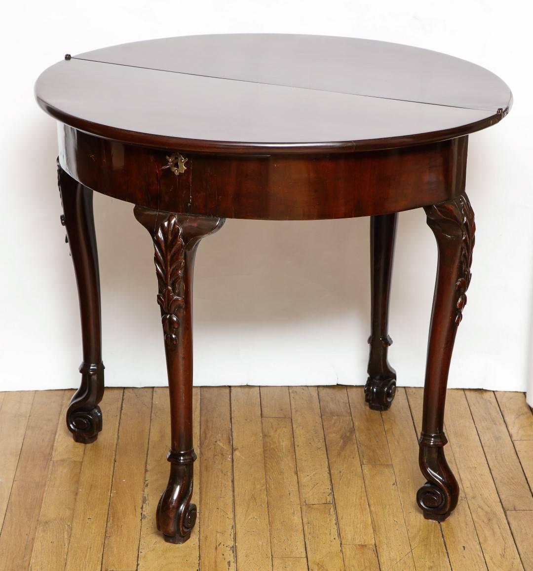 A George II Irish mahogany games table, shell carved knees terminating in scrolled feet.

Dimensions;
Closed-29