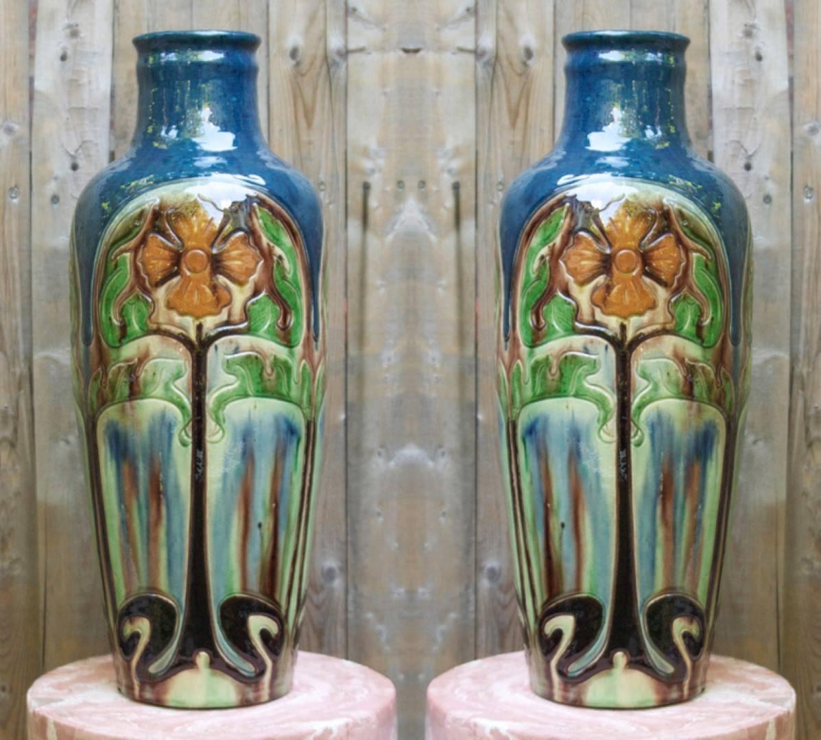 A pair of Belgian ceramic vases with Arts and Crafts stylized floral motifs.