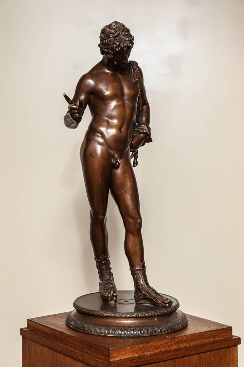 A 19th century Grand Tour bronze depicting Narcissus signed by the Chiurazzi Foundry in Naples. The lifelike figure with shoulder draped in animal pelt wearing detailed sandals and headband on round base with leaf tip details. The bronze sculpture