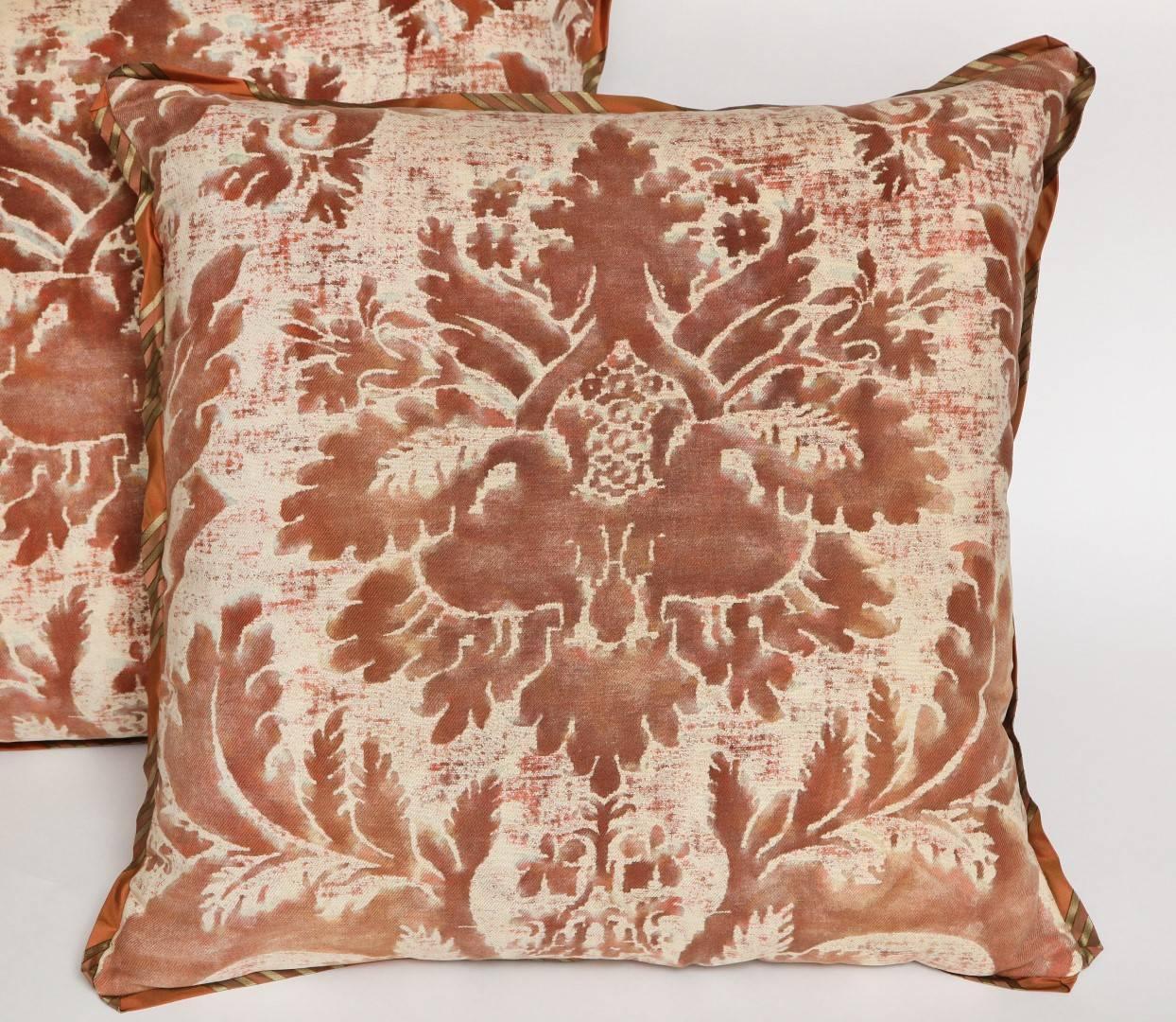 A pair of Fortuny fabric cushions in the Glicine pattern, caramel and white color way, cotton/linen blend backing material and striped silk bias edging, the pattern, 17th century Italian design with Wisteria motif. Newly made using vintage Fortuny