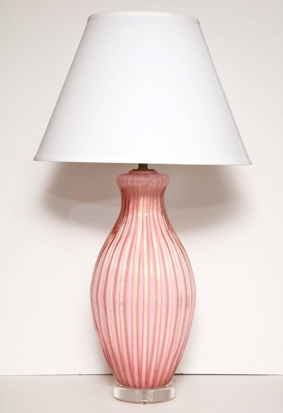 A pair of Italian pink Murano glass table lamps, fluted baluster form on circular Lucite base, fitted for electricity.