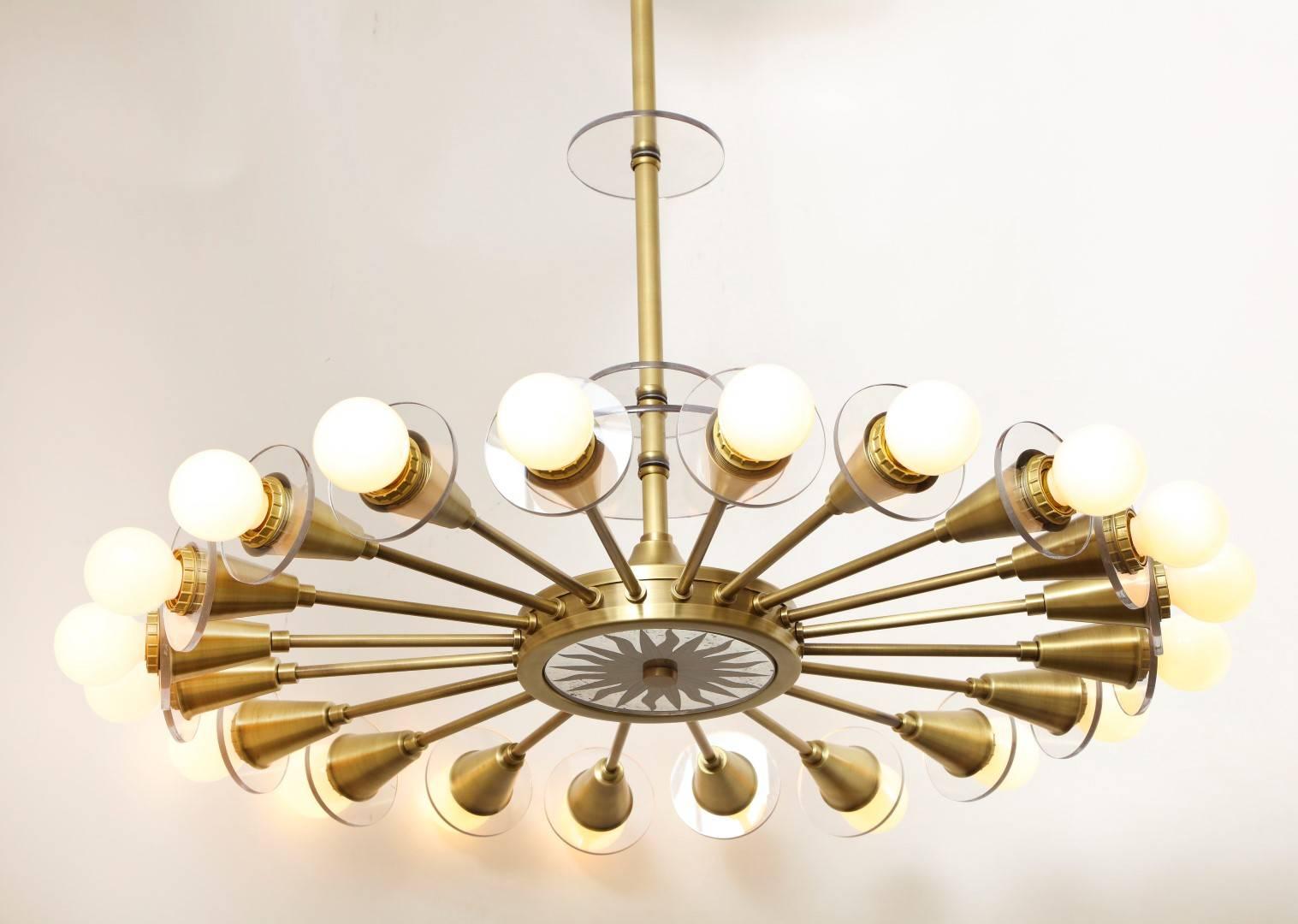 The Odom 20-Light mirrored sunburst fixture. The brass frame with round mirrored insert on oversized ceiling medallion and underside of fixture having eglomise sunburst motif inset in brass frame, the underside secured by finial in center of glass