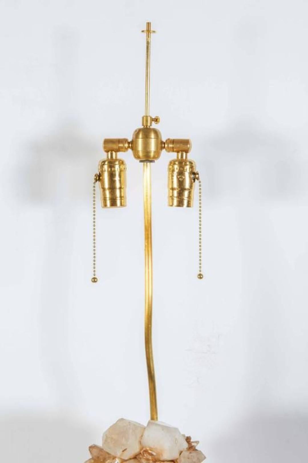A Carol Stupell quartz rock crystal table lamp, organic form rock crystal spears resting on a two tiered giltwood plinth base, with double cluster fitting, wired for electricity.