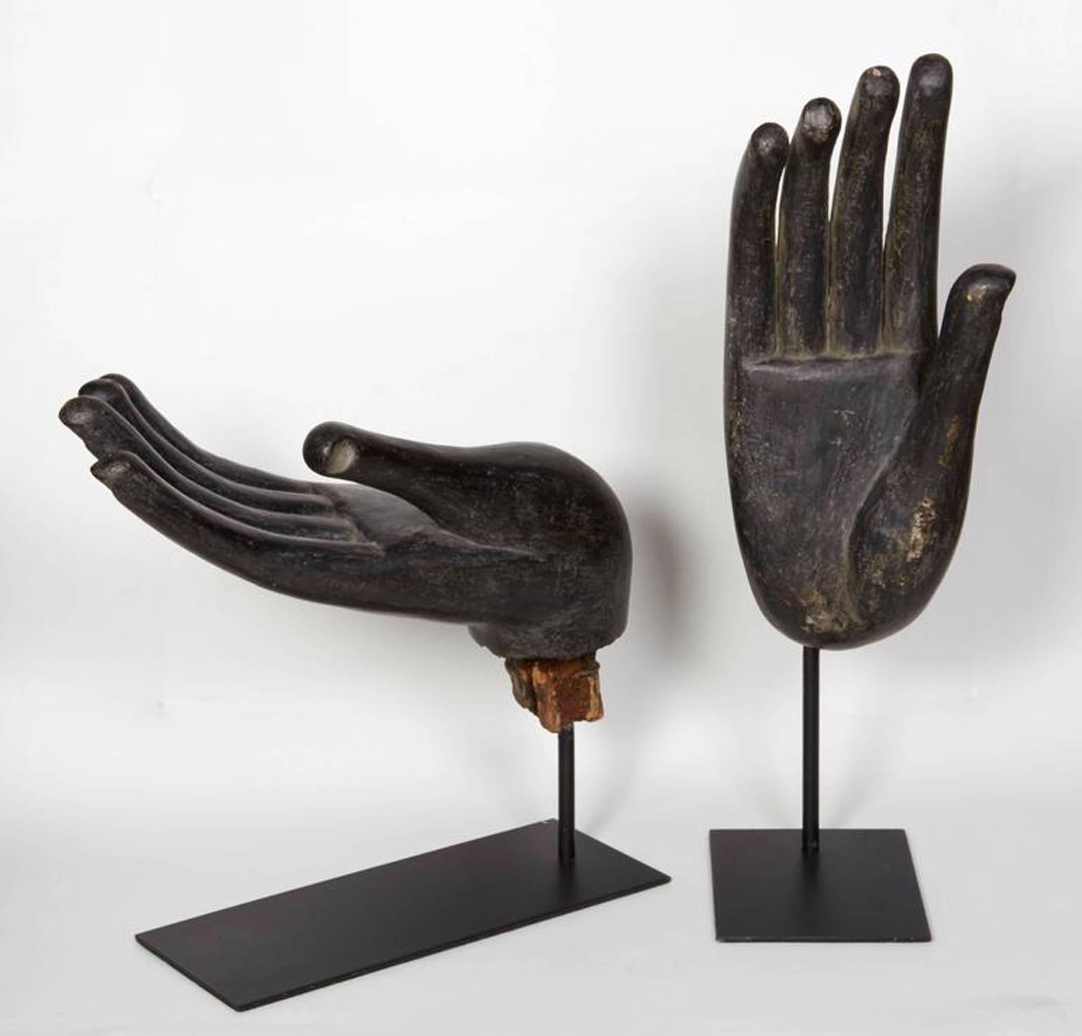 Two black Buddha hands, each depicting a traditional gesture or madras. Mounted on metal stands. Country of origin: Thailand. Excellent condition. Priced and sold separately.