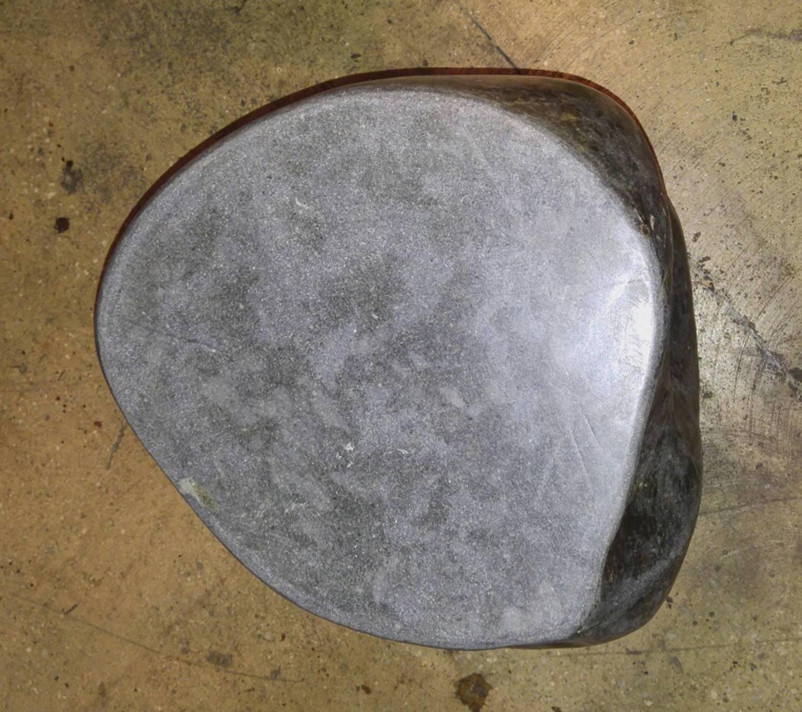 A solid stone end table or stand with polished sides and top, from Indonesia.