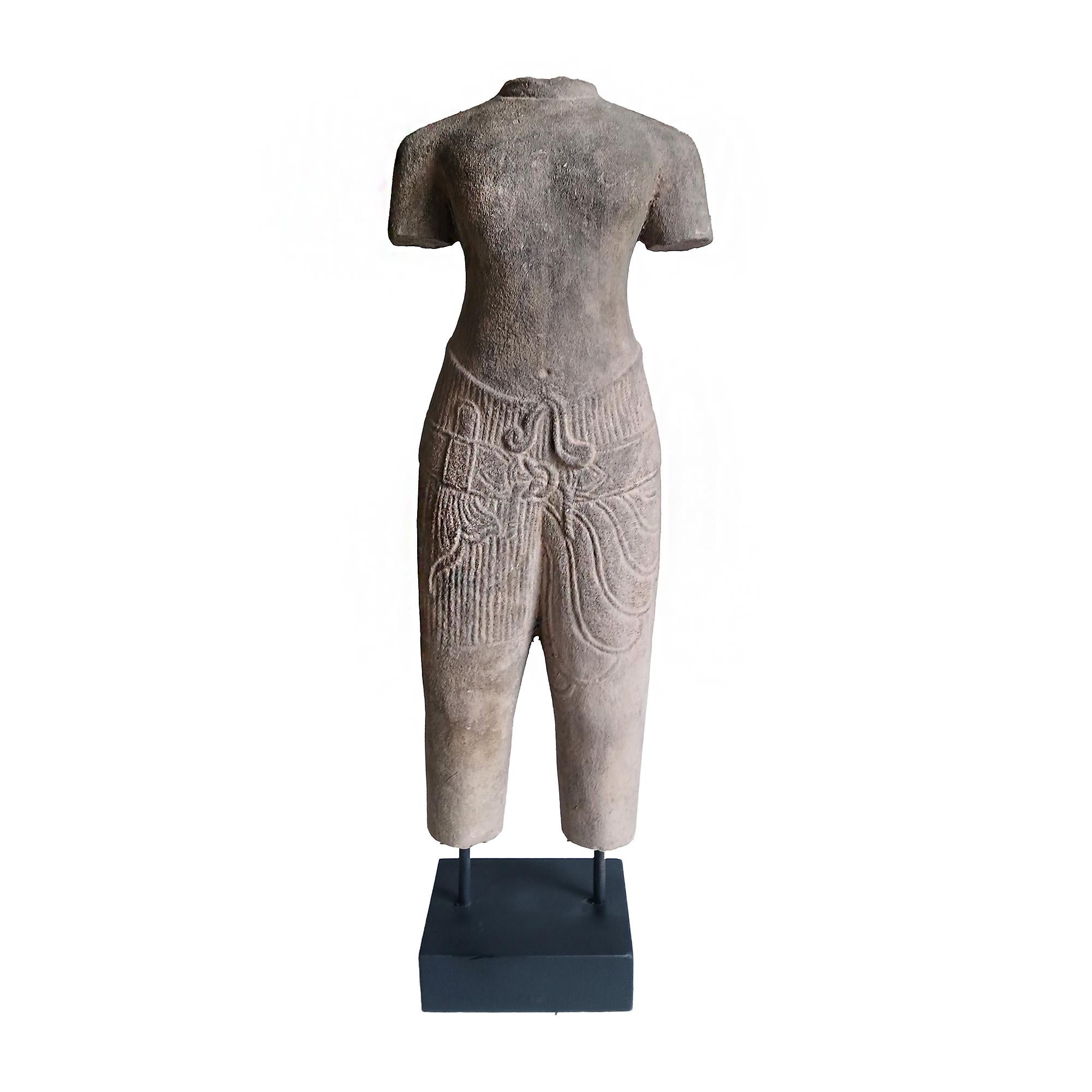 Sculpture de table représentant un torse masculin en tenue traditionnelle, sculptée à la main dans un seul morceau de grès altéré, conservé dans sa couleur naturelle. Thaïlande, fin des années 1970. 

Conception et détails complexes des vêtements.