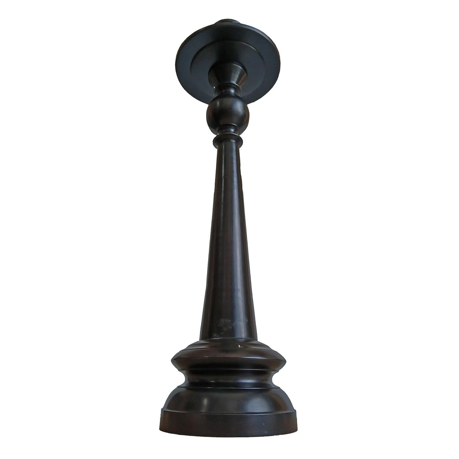 A tall candlestick in forged bronze with black satin finish. Indonesia, contemporary.

The 9-inch diameter top plate is designed to hold pillar candles up to 6 inches in diameter. It also  includes a removable top that holds candles up to 3 inches