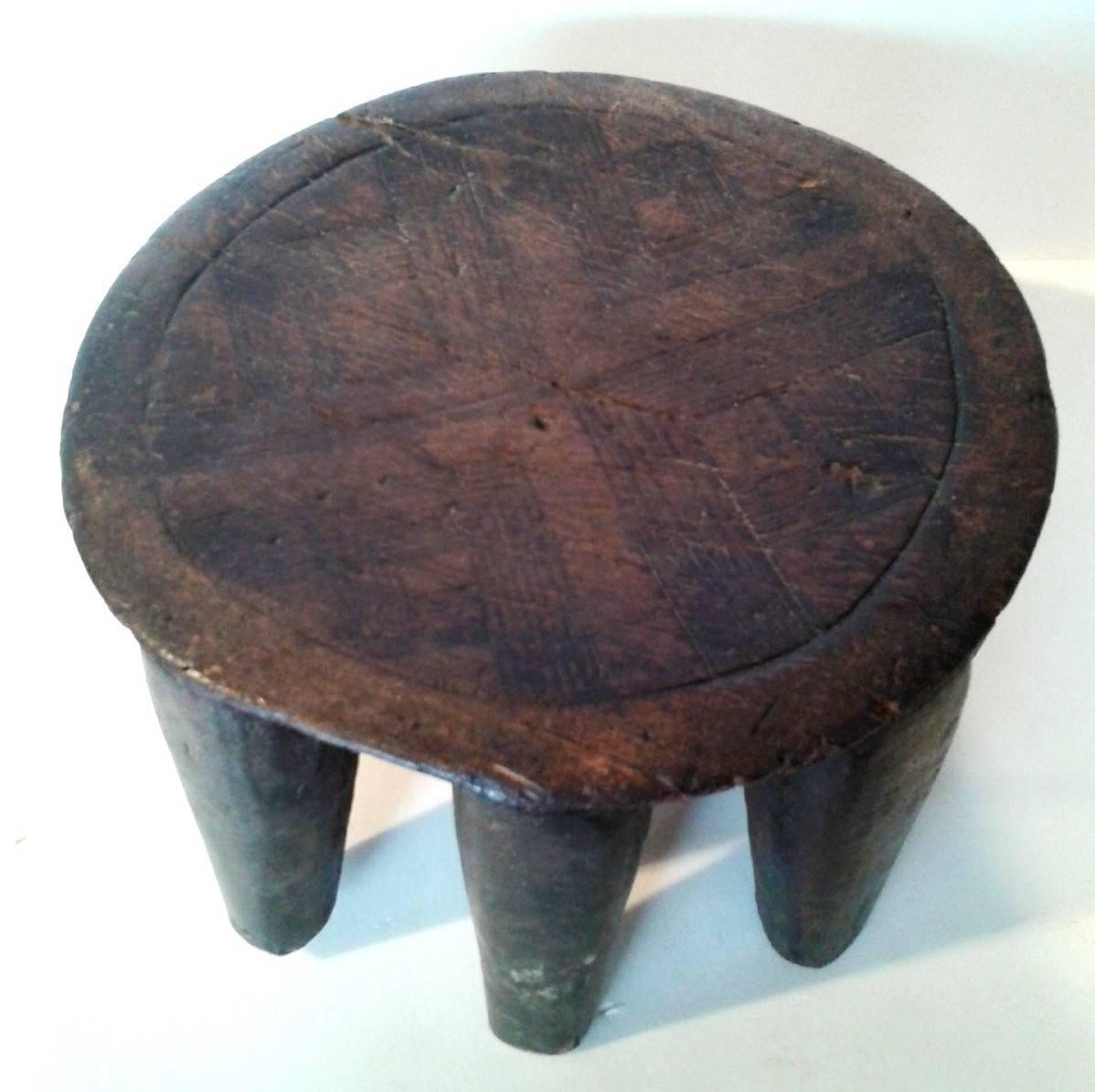 A Nupe chief stool from Nigeria, carved from a single piece of wood. Decorative carvings on top. Exotic accent as a side table, small Stand or decorative object.