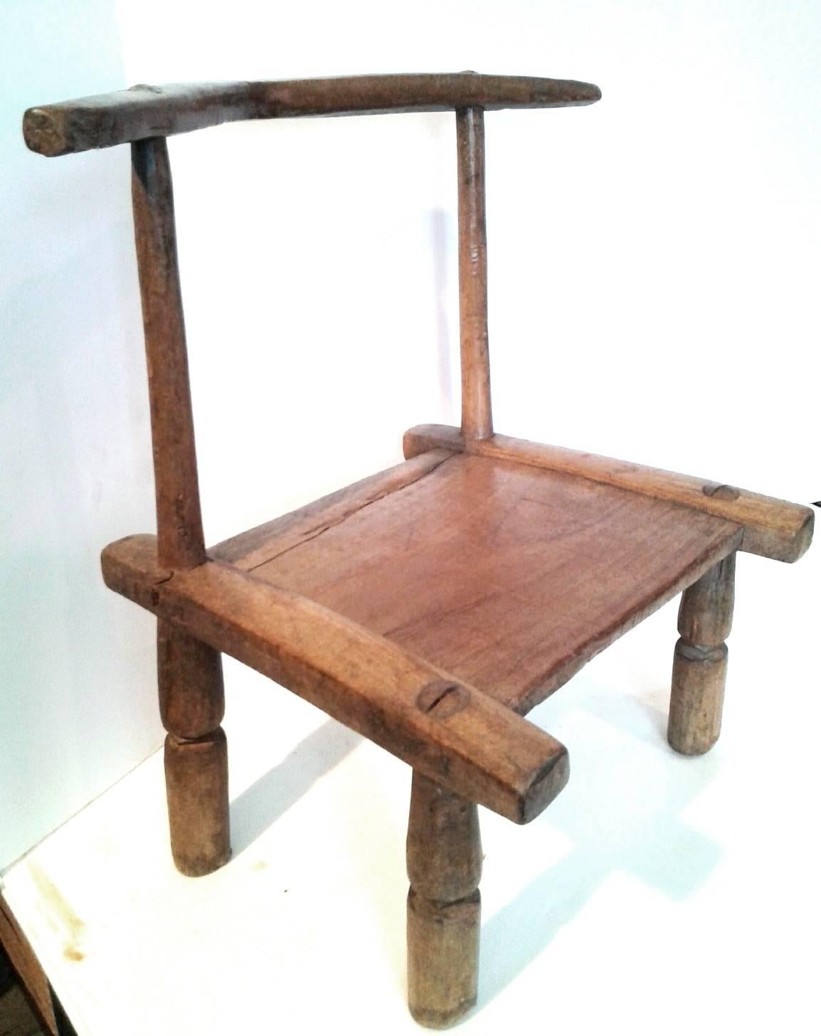 Chaise Baoulé originale en bois de la côte d'ivoire, sculptée et assemblée à la main. 

Les chaises des tribus Djimini et Baoulé de Côte d'Ivoire ont un design typique, bas avec un dossier vertical. Traditionnellement réservées aux membres de la