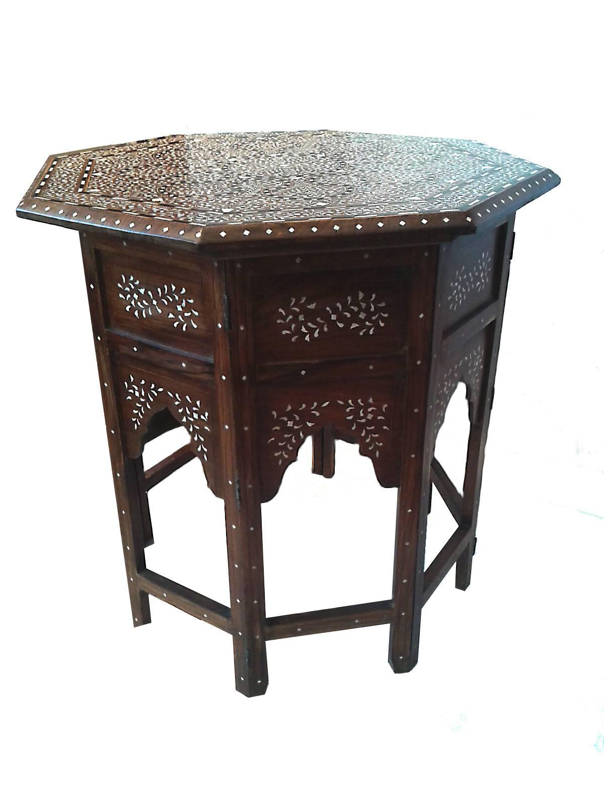An octagonal side or end table with bone inlays, from India. Detachable folding base. Classic inlay pattern.
