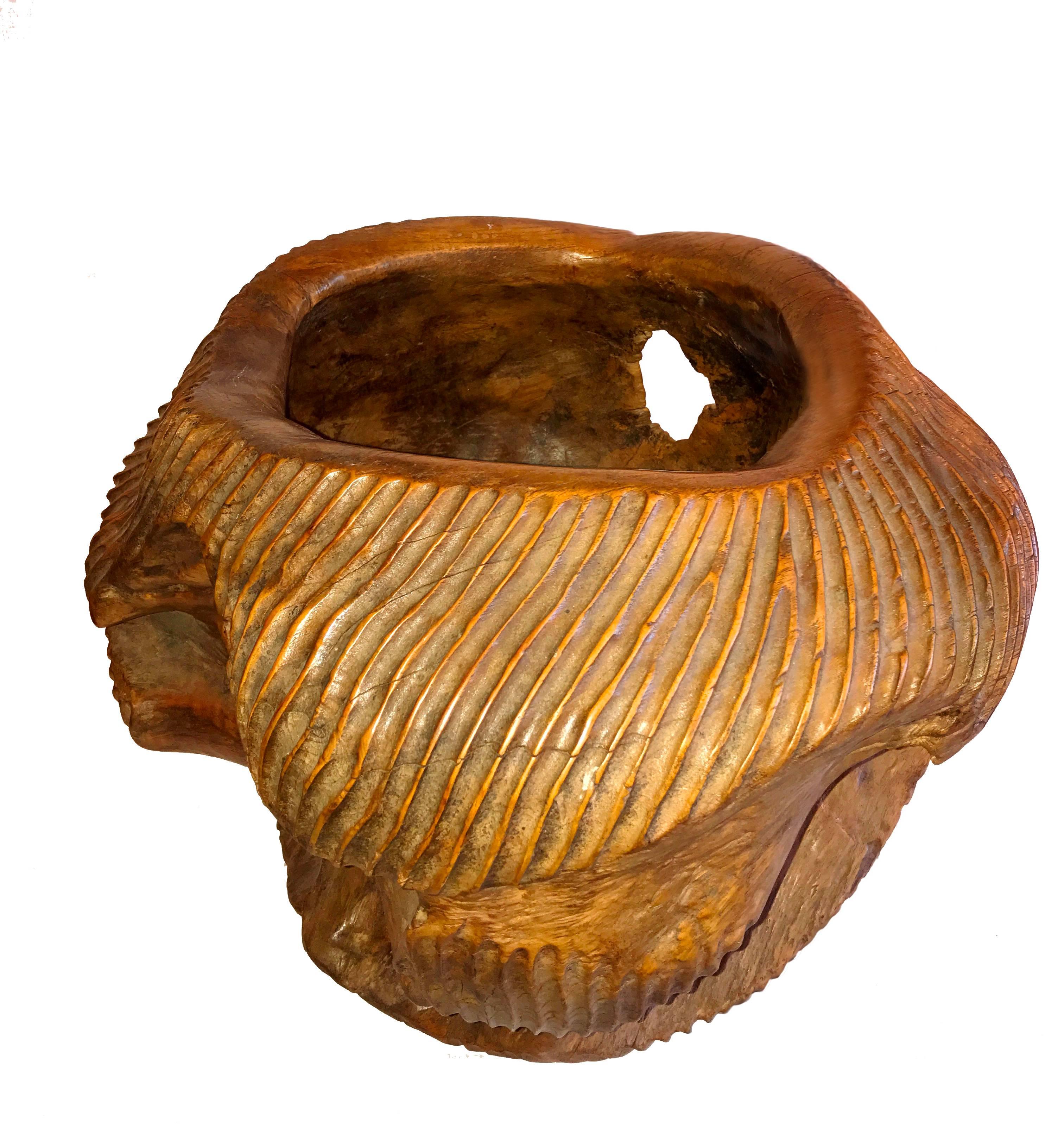 An ornately carved bowl from Indonesia. Hand-carved from a solid piece of Ironwood, this deep bowl exhibits the richness and warmth of the wood texture, combined with an intricate and whimsical carving that makes it a truly original piece.