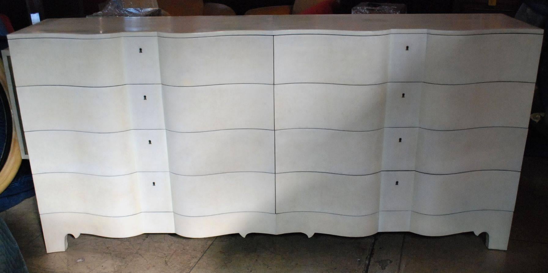 Elegant serpentine front features eight very large drawers cover with natural parchment sideboard.