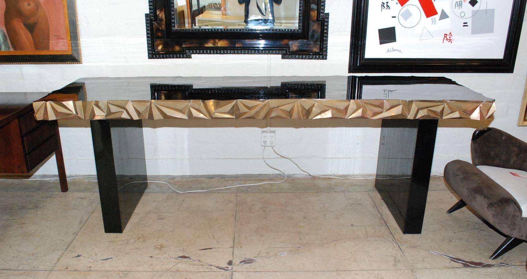 A fantastic hand-carved wood black lacquered and brass wrap console table.