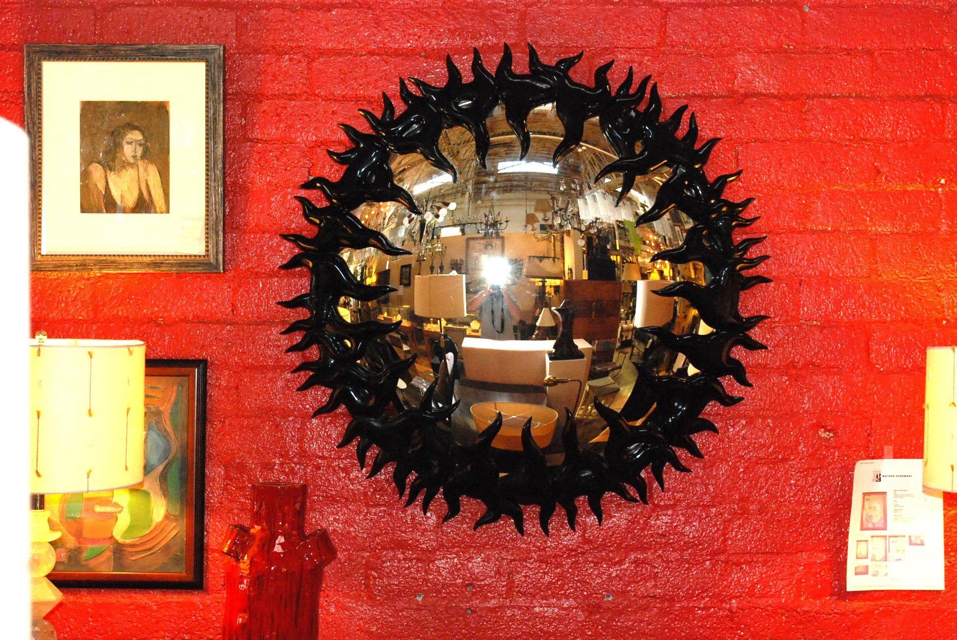 Großer, handgeschnitzter, schwarz lackierter, konvexer Spiegel aus Holz.