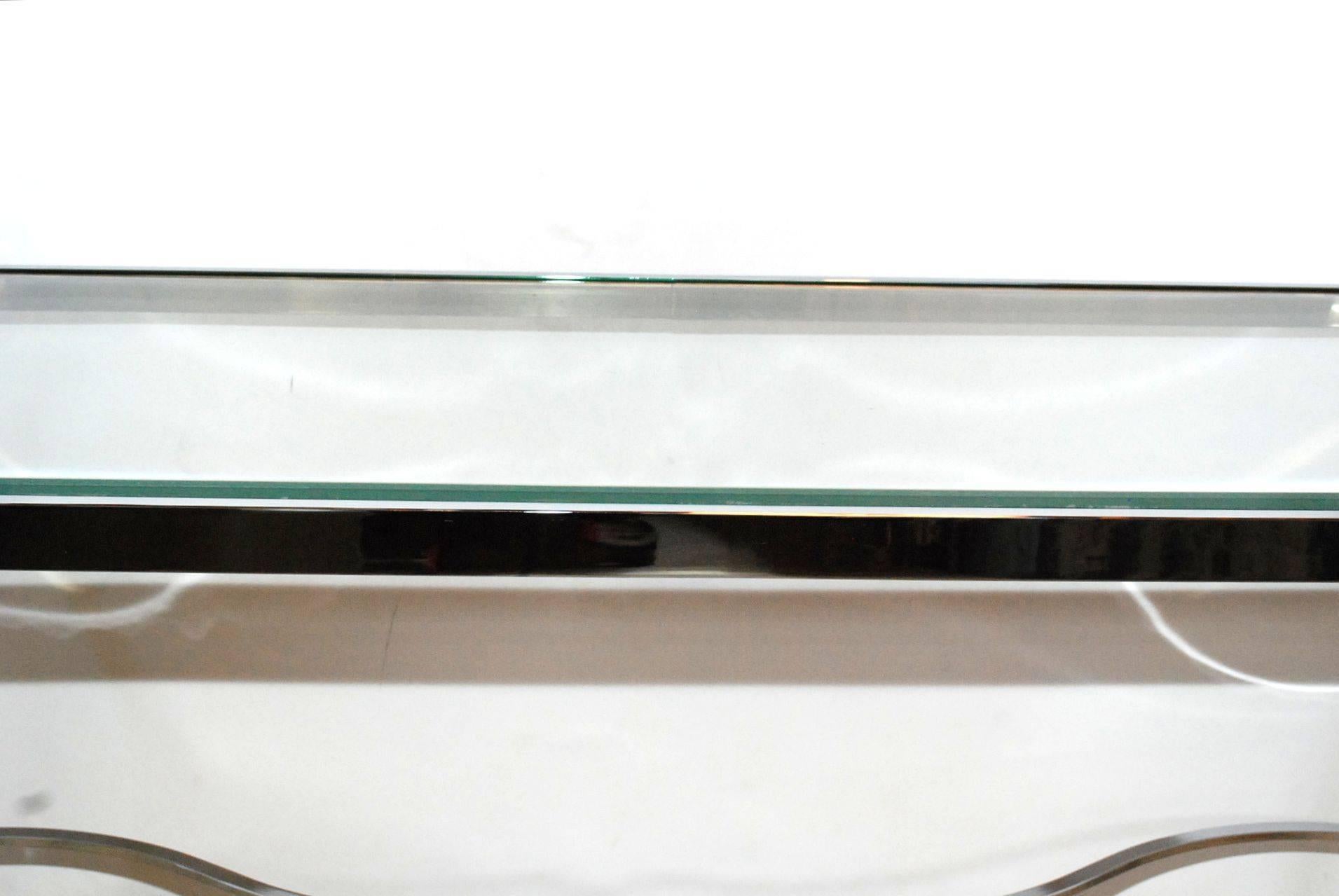 Table console avec plateau en verre et détails en laiton.