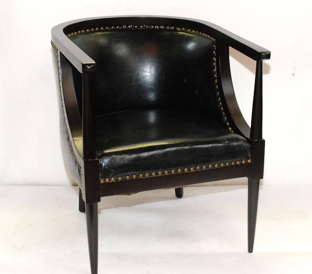 1960s pair of dark walnut barrel armchairs with original black vinyl and spring.