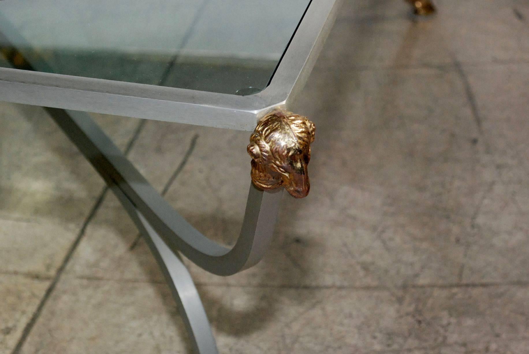 Square rams head motif steel and brass coffee table with glass top in the style of Maison Jansen.