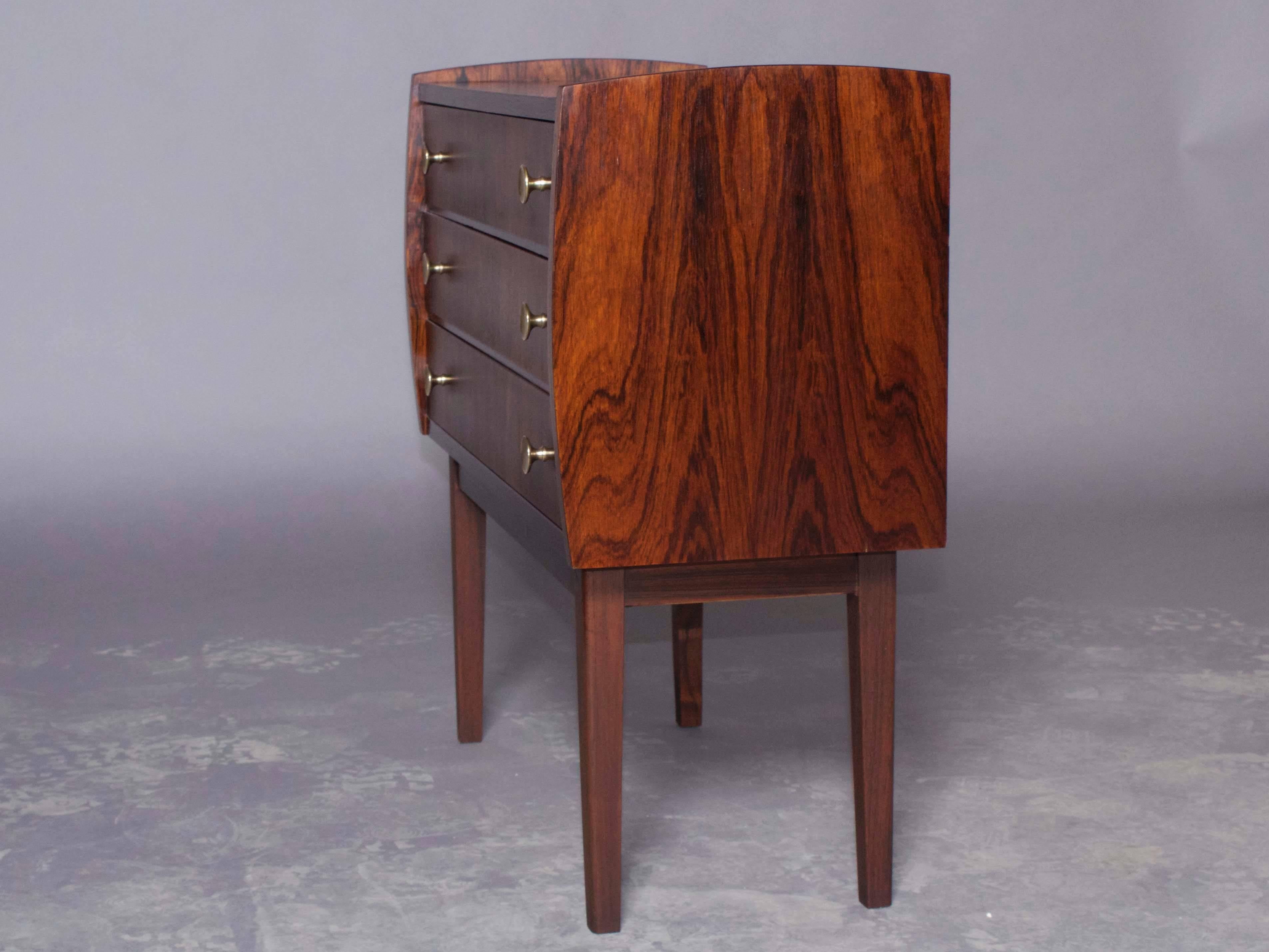 Vintage 1960s Rosewood Side Table from Denmark

Top quality rosewood bedside table with three drawers and brass pulls. Ready for pick up, delivery, or shipping anywhere in the world.