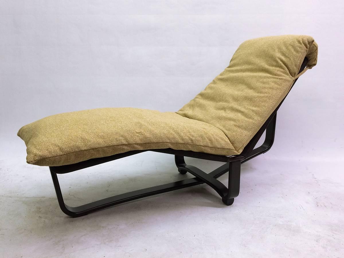 This reclining lounge chair is composed of a thick, very comfortable, chenille upholstered cushion on an ebony stained bent-wood frame and a stretched canvas seating surface. The chair sits in two positions, one upright and one reclined. The