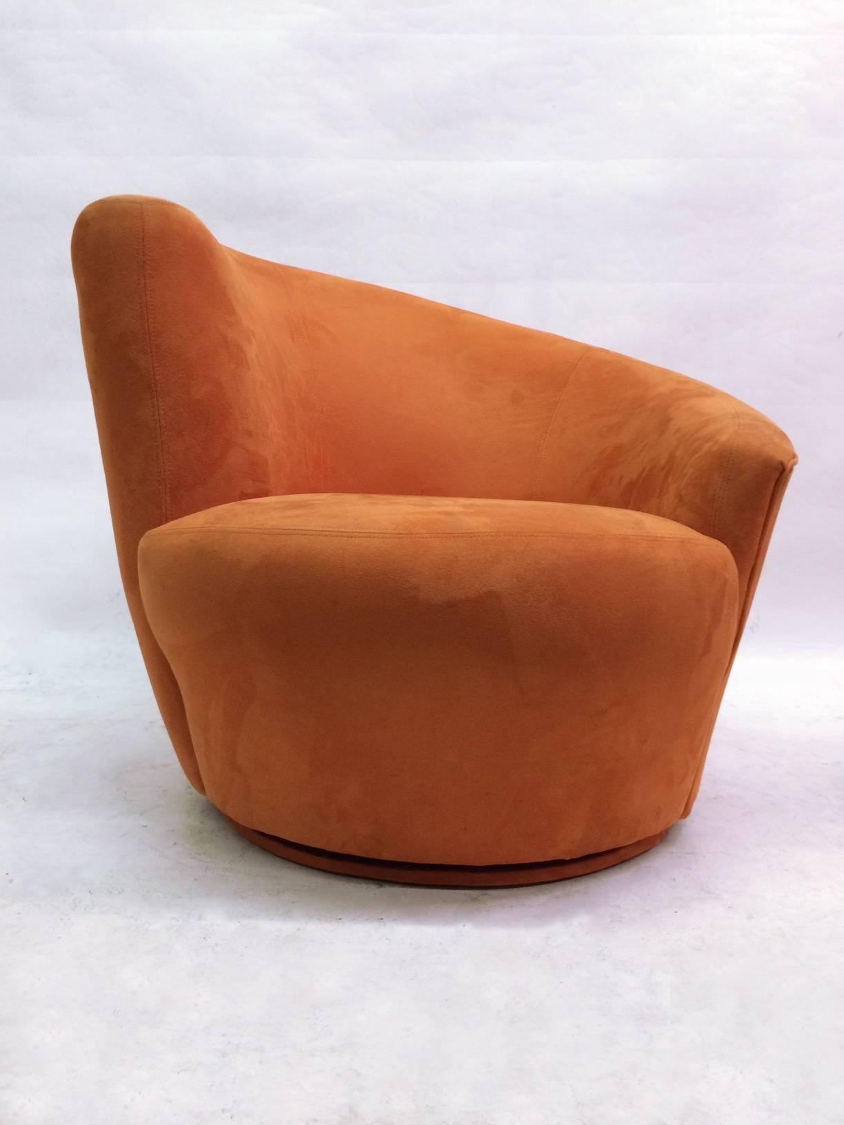 A pair of Classic Nautilus chairs designed by Vladimir Kagan for Directional featuring sloping, asymmetrical backrests. These lounge chairs rest upon swiveling bases which allow them to rotate 180 degrees and then return to their original