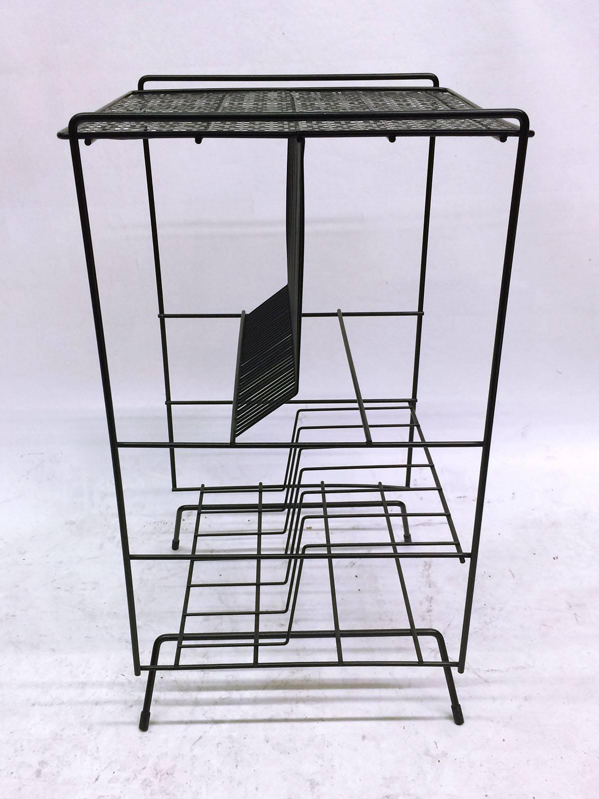 This Mid-Century bent steel media/record stand is powder coated. The stand has a flat surface on the top for a player, and two shelves for records one for single records and the other for groupings.