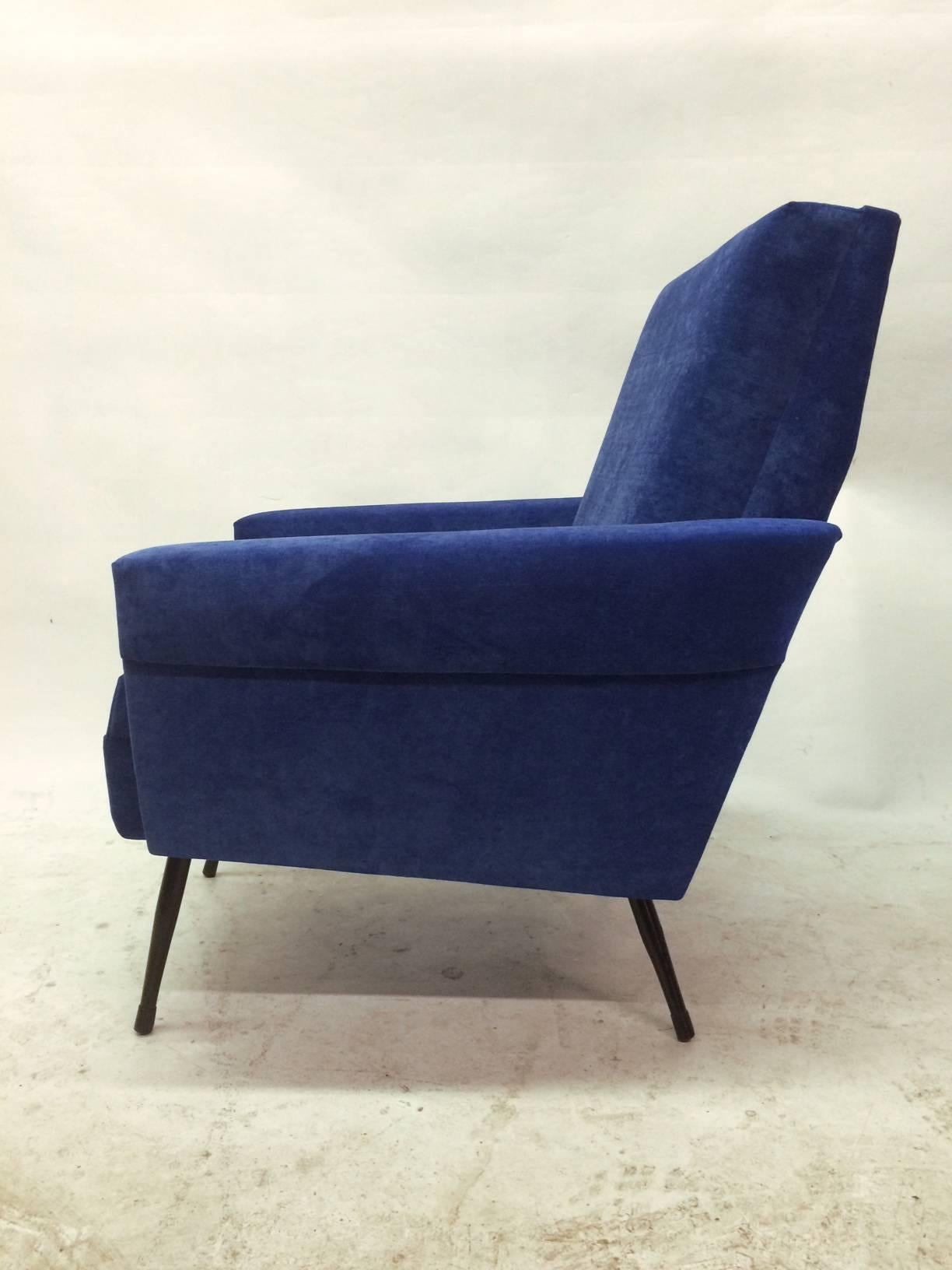 This pair of French 1950s lounge chairs is eye-catching in both structure and finish. These chairs are very comfortable. They feature black lacquer steel legs and have been reupholstered in a vivid blue velvet. 