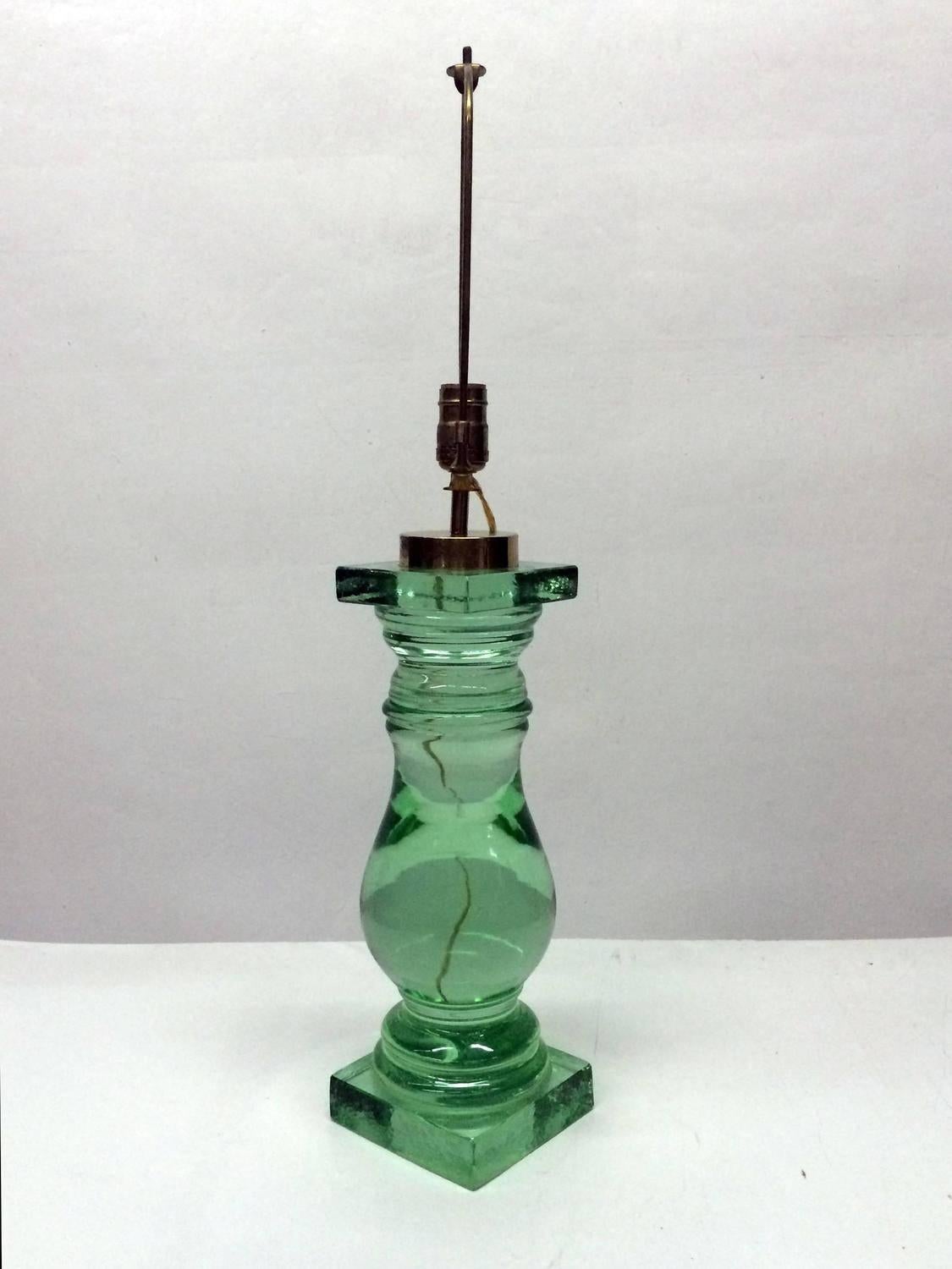 This green Murano glass table lamp has the elegant shape of a turned spindle or carved column. The glass lamp base is finished with brass fittings.
It is made in a big chunk of glass.