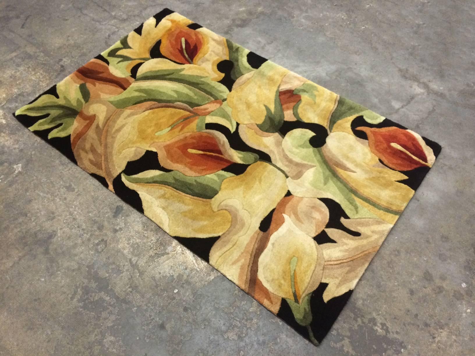 This colorful floral rug in mostly sensuous pastel tones and floral imagery has lots of contrast through dark black negative space. 
The rug features a dense plush wool pile.