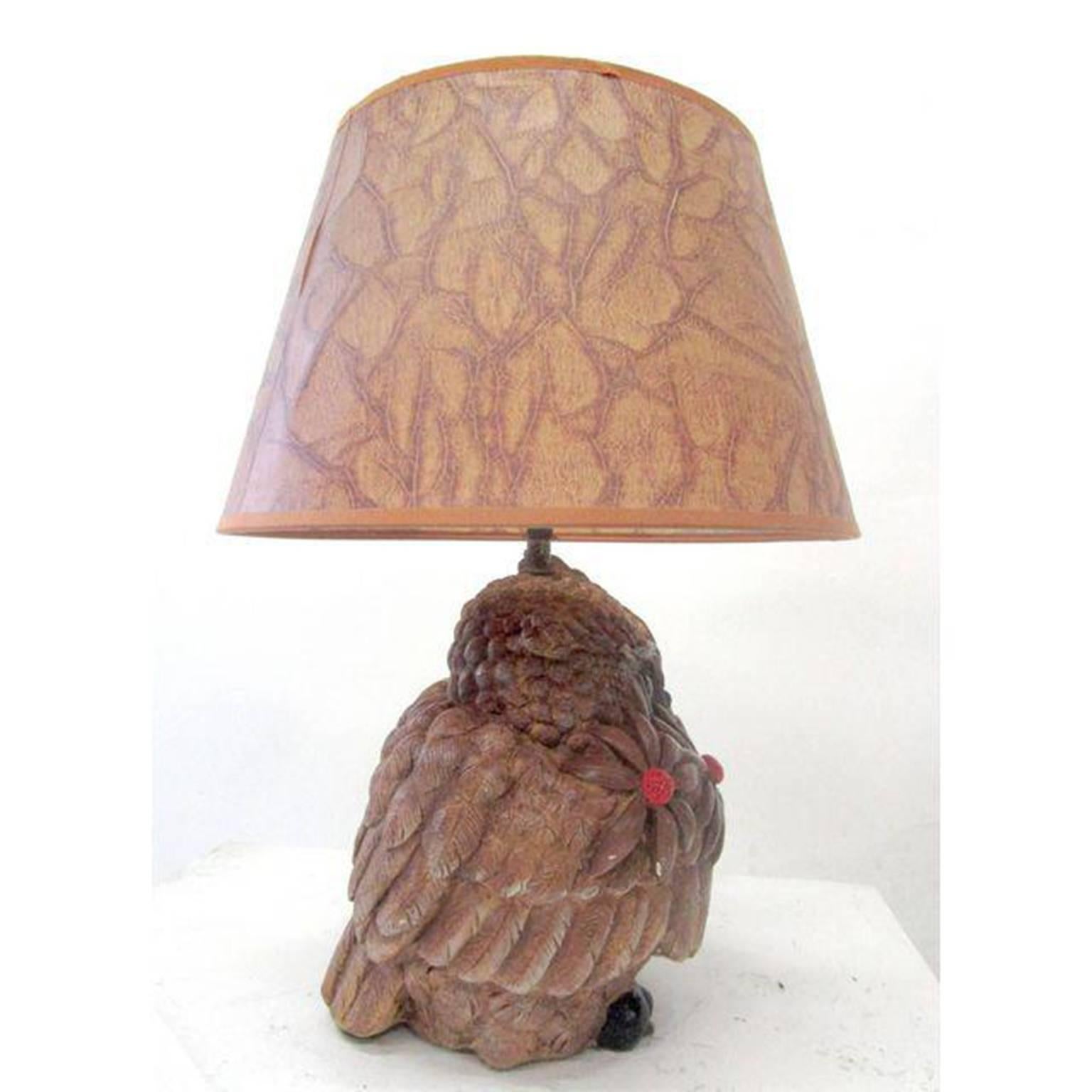 The base of this Mid-Century owl lamp is composed of a single block of wood that has been hand-carved with incredible detail in the feathers and face. The lamp, wired and in working condition, is topped off by a brown flared shade with a unique