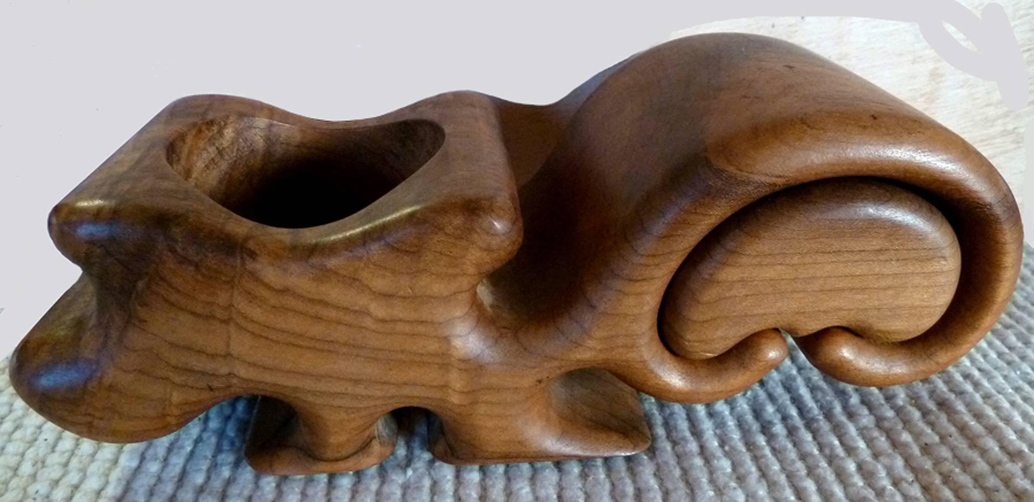 Decorative box or keepsake holder has a beautiful wood grain and seems to resemble a squirrel. Has one small pullout drawer and one circular opening at the top, perhaps to hold a candle or small valuables.