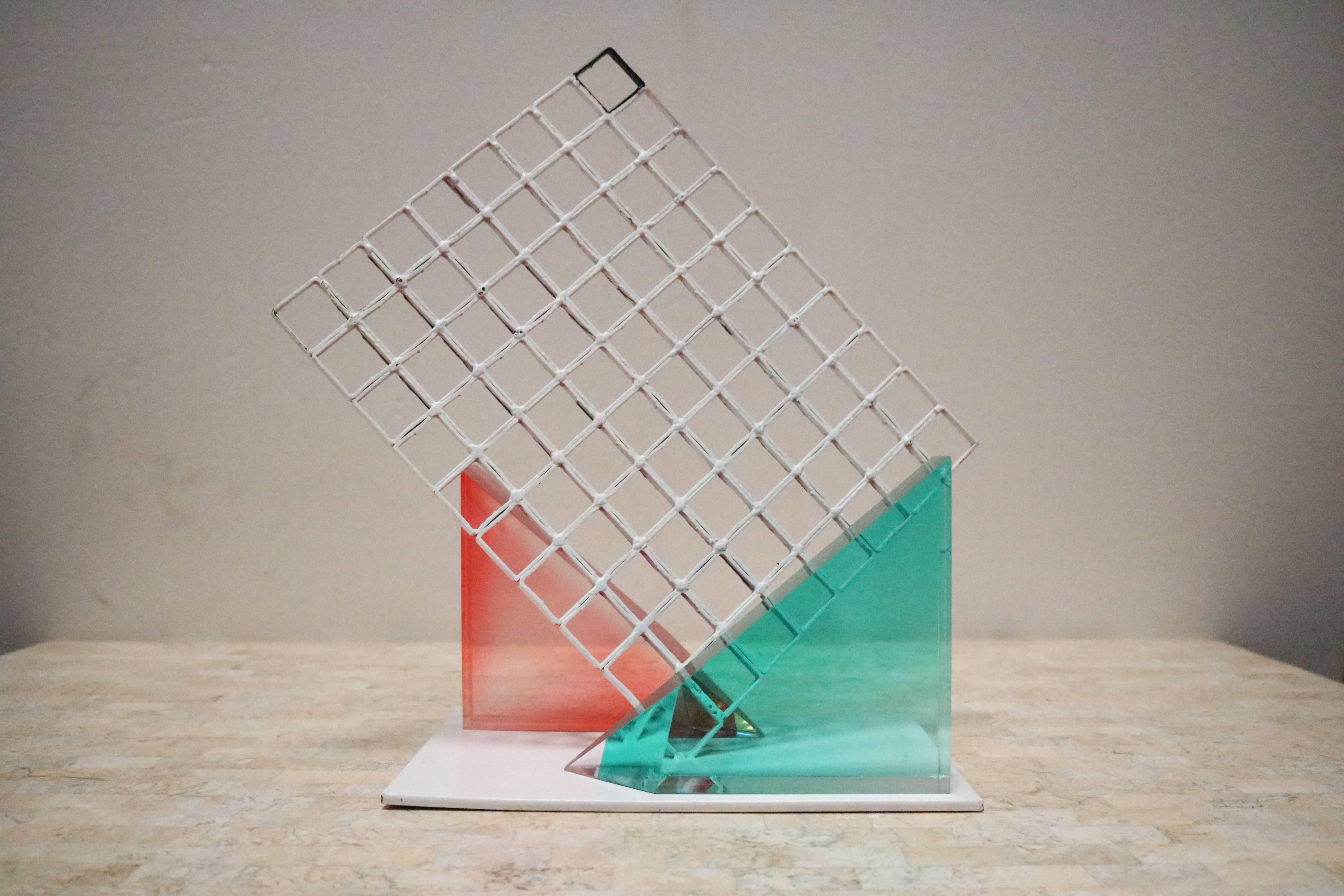 1980s Memphis style sculpture is composed of three pieces. A white metal grid and attached base, and two triangular Lucite pieces that we have arranged on either side. Lucite pieces are not permanently attached and can be moved and used elsewhere as