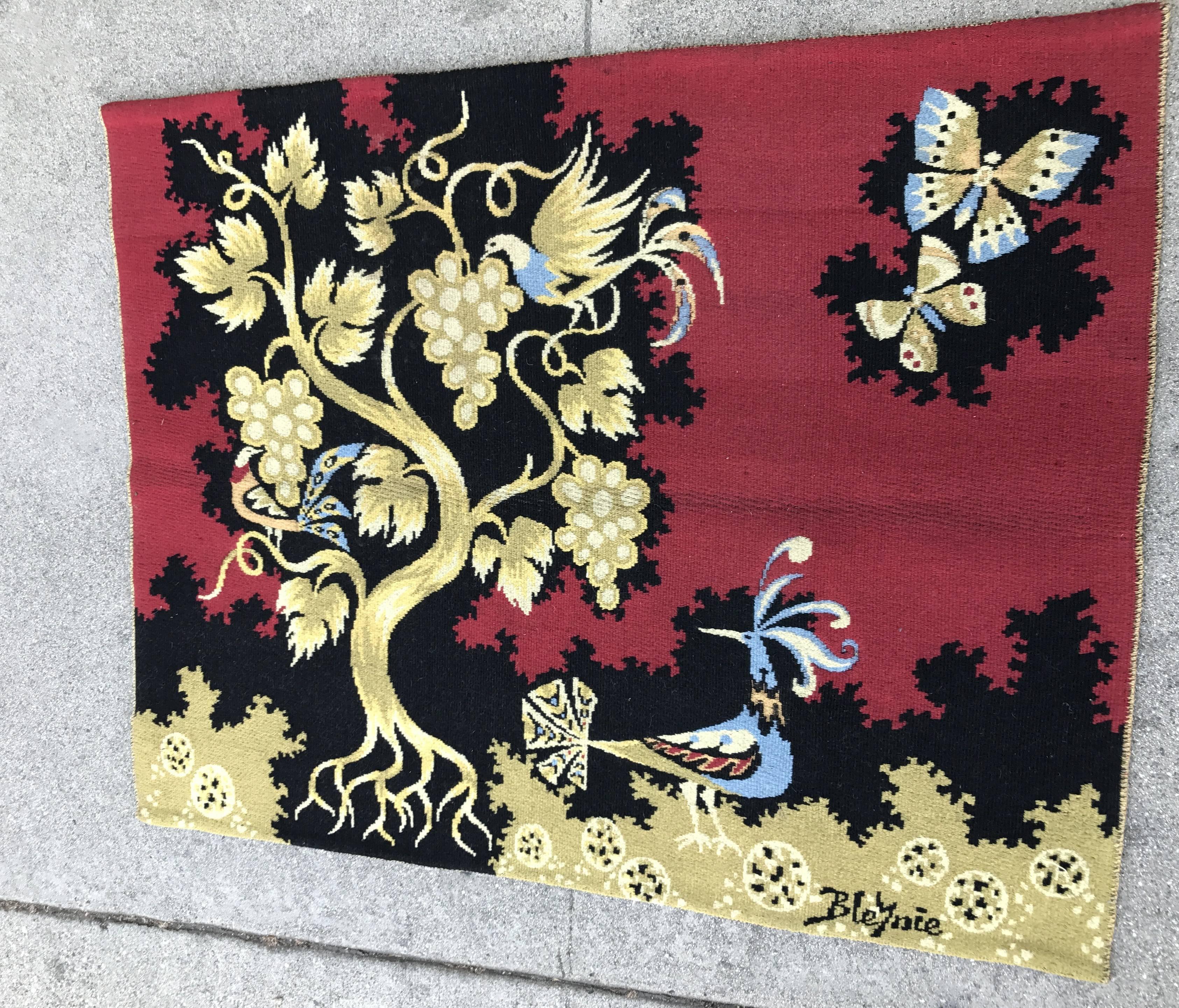 Claude Bleynie was a French artist, born in 1923. He discovered the art of tapestry with Jean Picart Le Doux in 1952.
Red wool handwoven tapestry with an intricate design of vines and peacock titled "Vigne D'Or". Made in Ateliers des