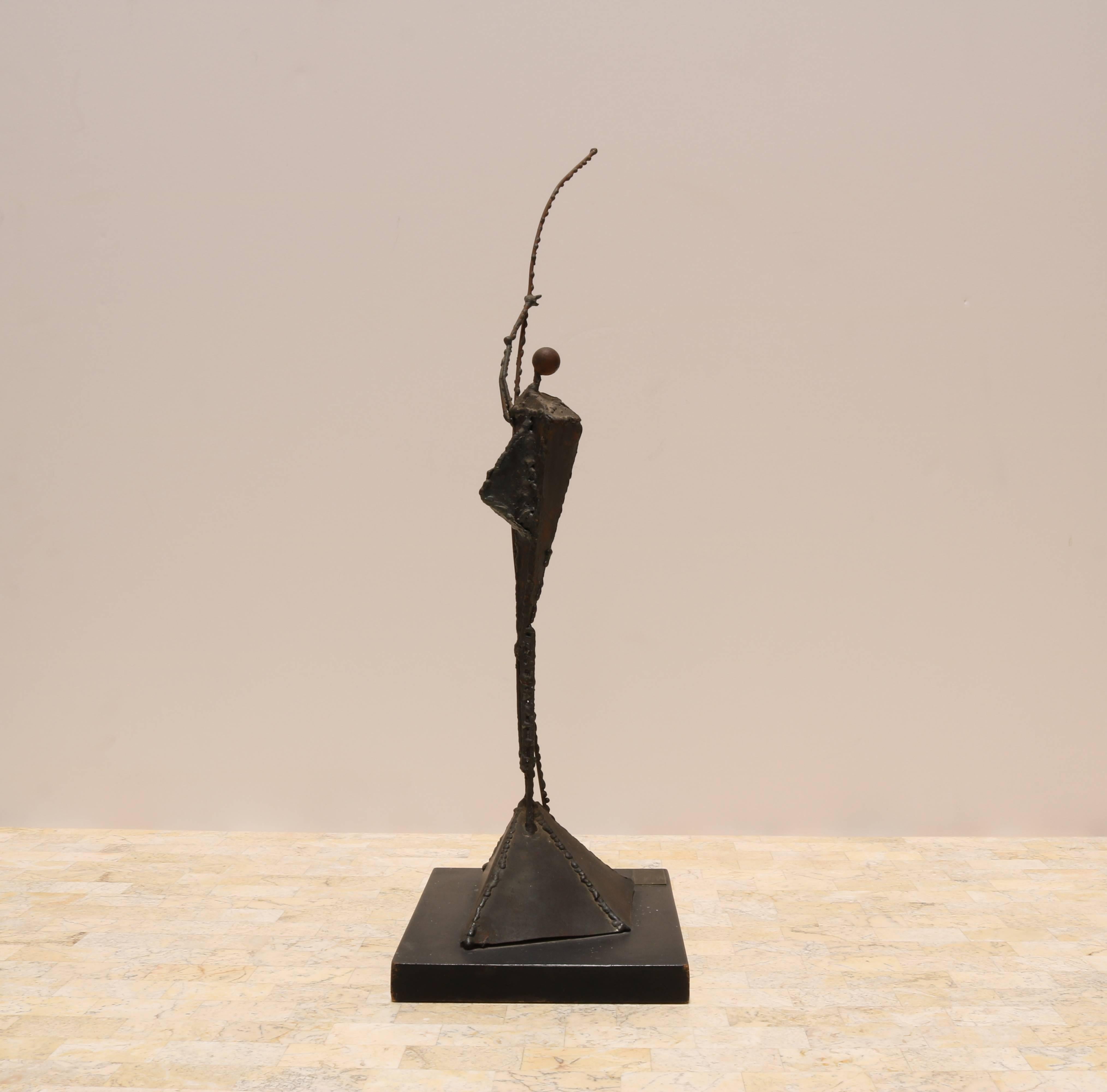 Brutalist metal sculpture of a figure standing on a hill and holding a spear or staff. Signed 