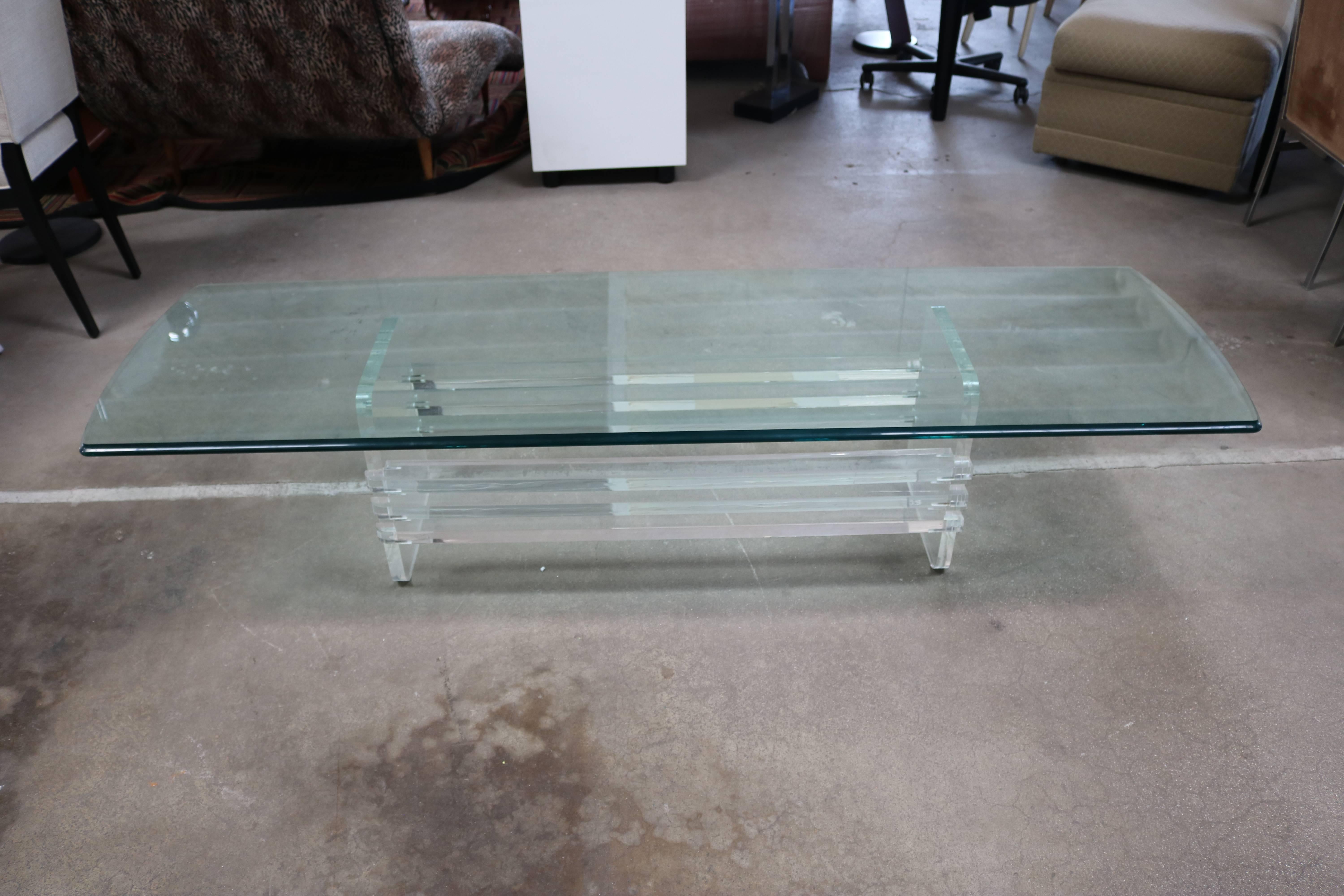 This long coffee table is made up of Lucite slats attached to two end pieces with a long rectangular glass top.